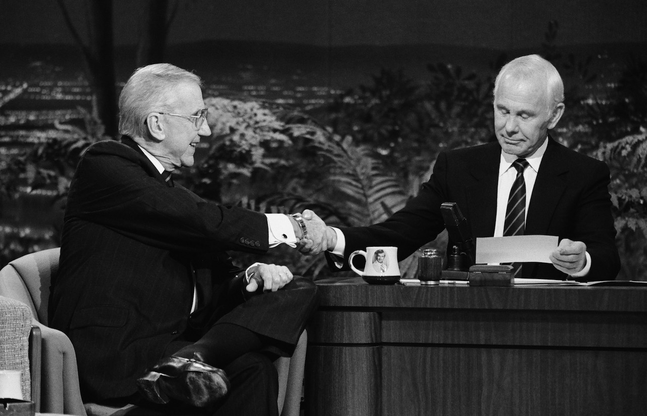 Black and white photo of Ed McMahon shaking Johnny Carson's hand on 'The Tonight Show' in 1989