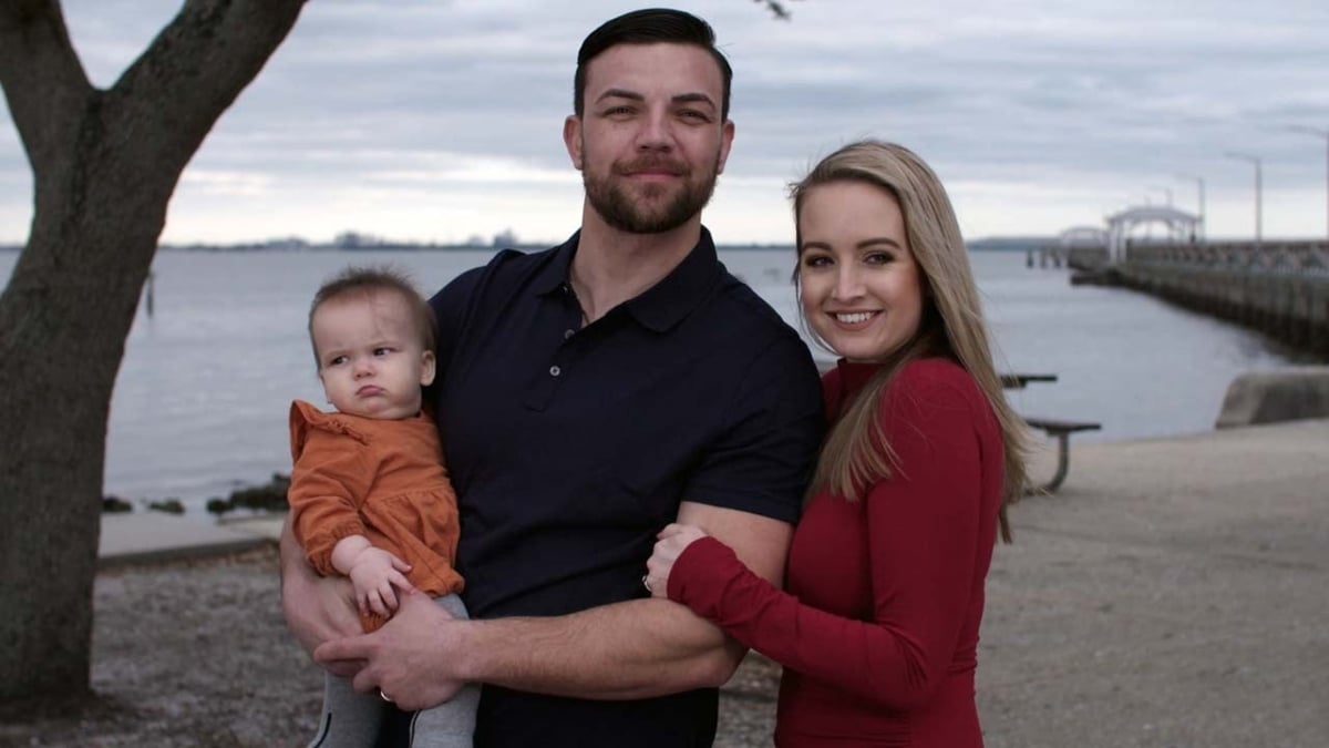 Andrei Castravet holding his daughter Eleanor with his wife,Elizabeth 'Libby' Potthast standing together in Florida for their promo for '90 Day Fiancé'.