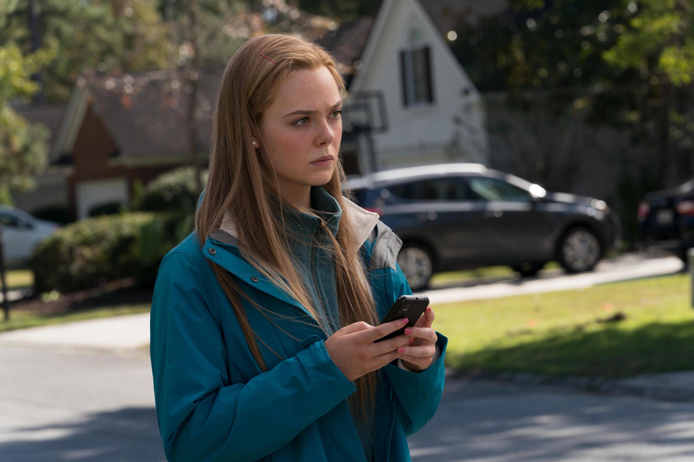 Elle Fanning as Michelle Carter texting while walking outside in 'The Girl From Plainville'
