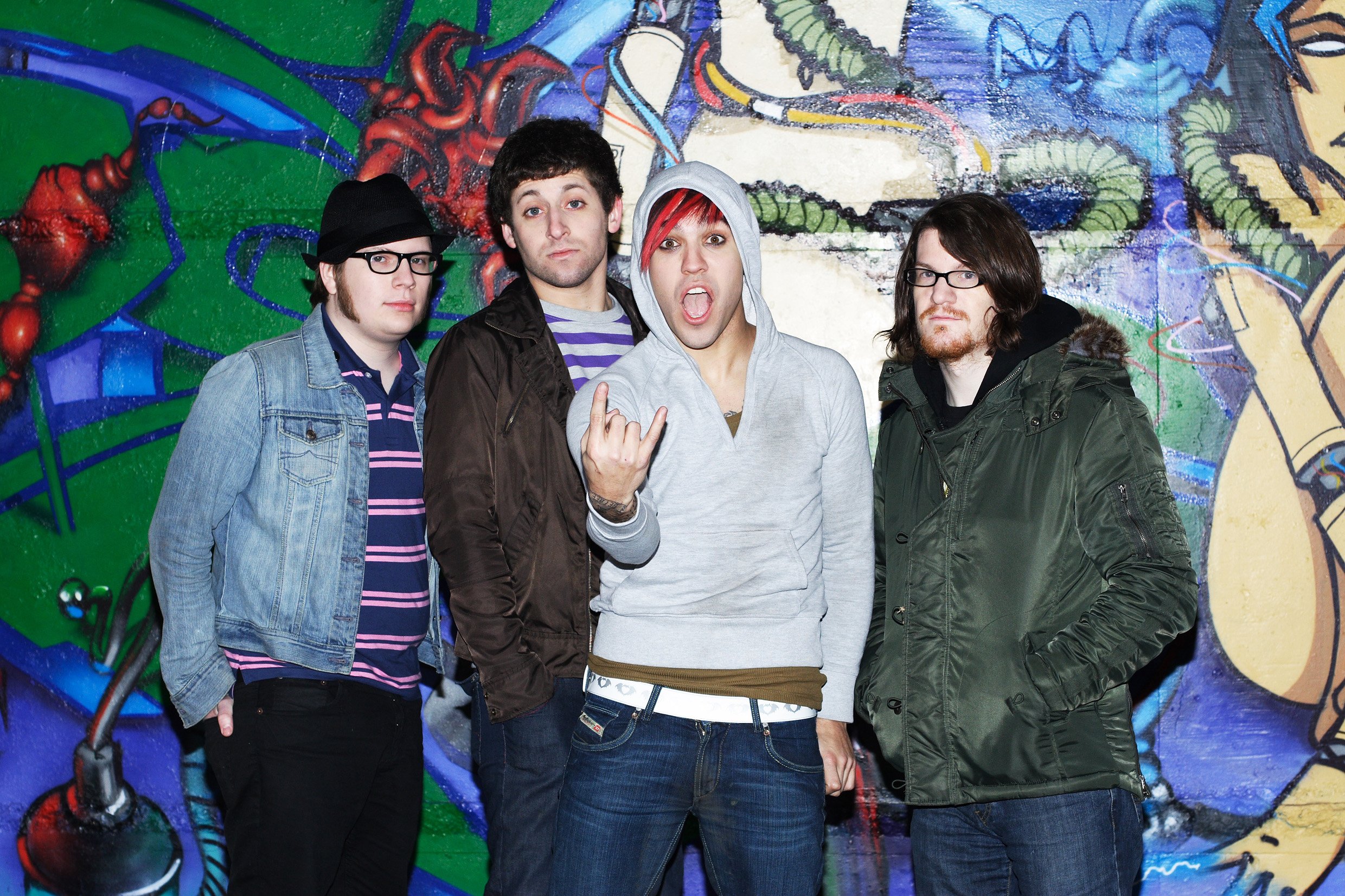 Fall Out Boy in front of a mural