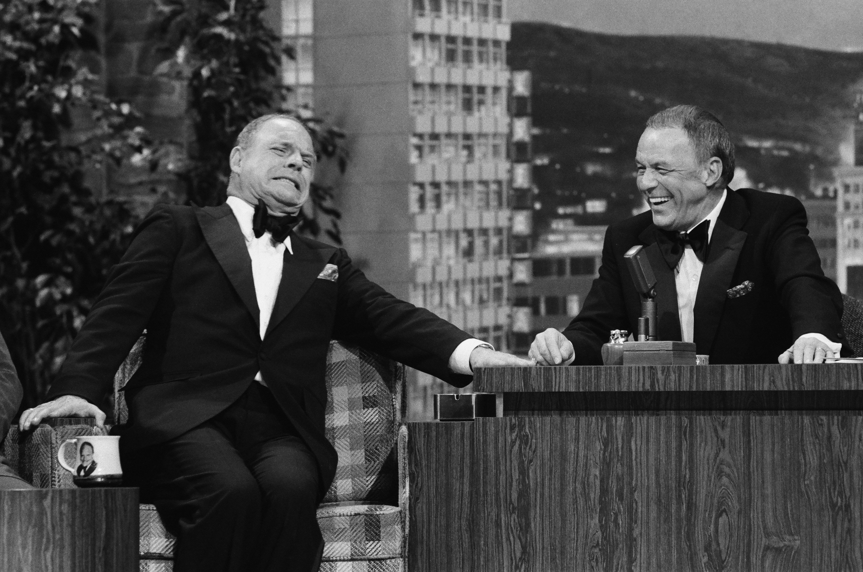 Don Rickles sits in an armchair and Frank Sinatra sits behind a desk as a guest host of 'The Tonight Show.'