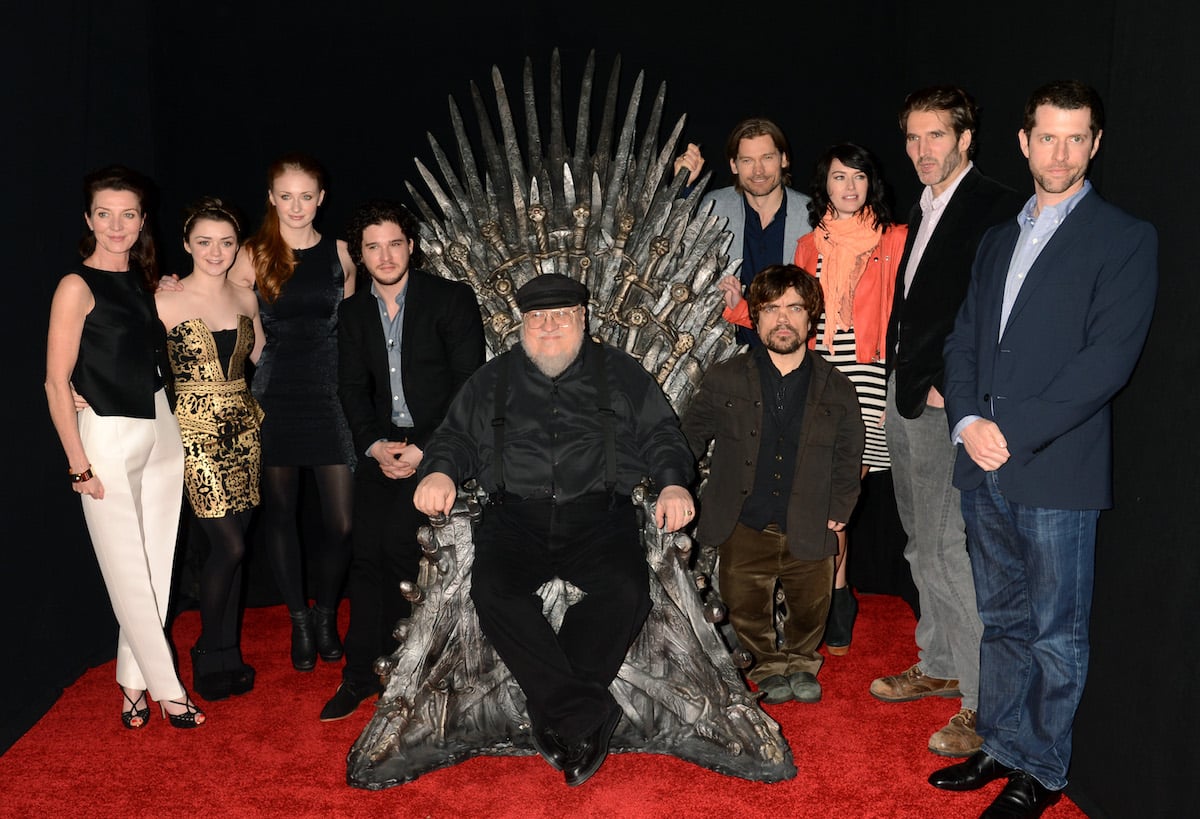 'Game of Thrones' actors Michelle Fairley, Maisie Williams, Sophie Turner, Kit Harrington, Peter Dinklage, Nikolaj Coster-Waldau, and Lena Headey surround author George R.R. Martin who sits on the Iron Throne