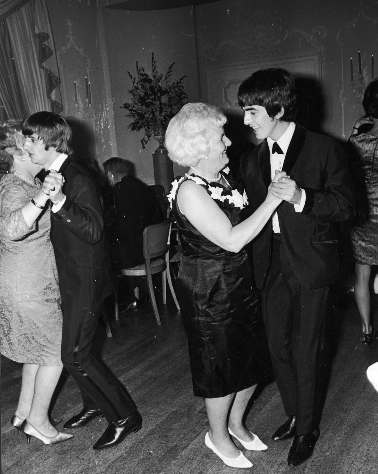 George Harrison dressed in a suit while dancing with his mother, Louise, in 1964.