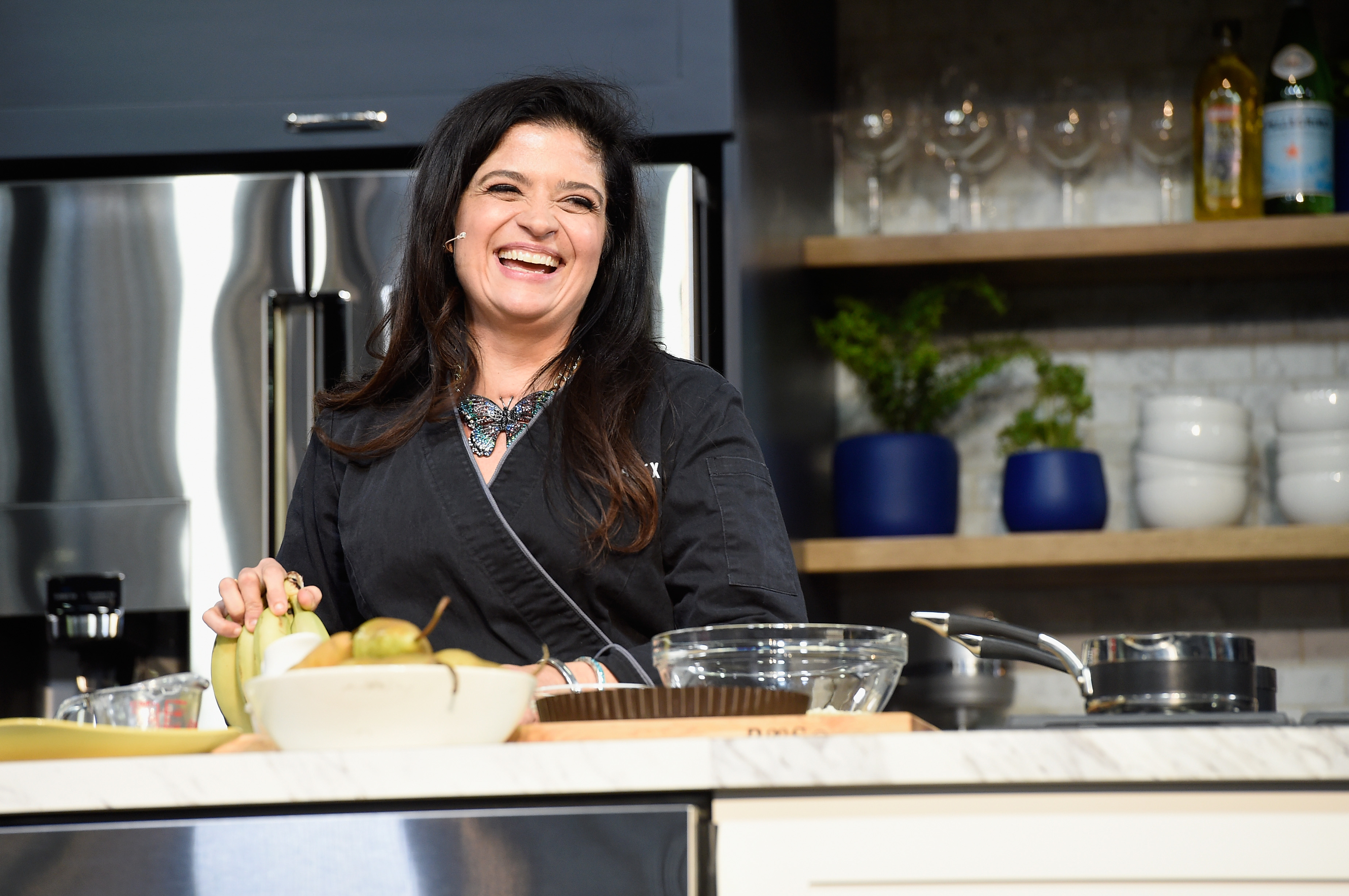 Food Network personality Alex Guarnaschelli wears a long-sleeved black blouse in this photo.