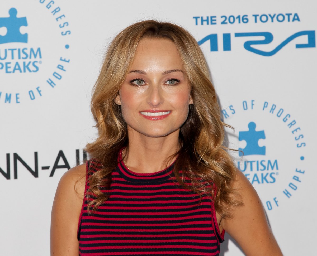 Food Network personality Giada De Laurentiis wears a sleeveless red and black blouse in this photograph.