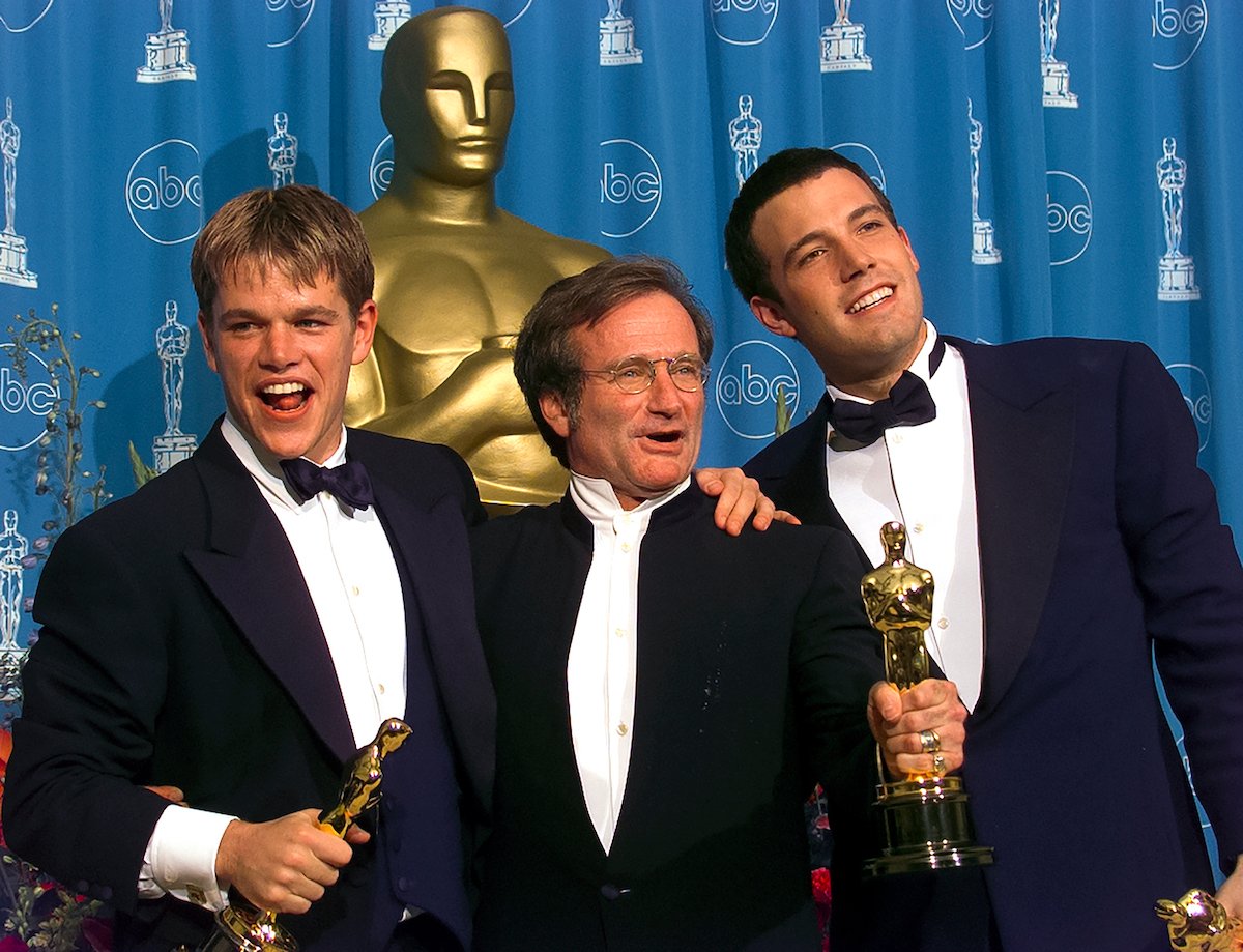 Matt Damon, Robin Williams, and Ben Affleck wear suits and hold their Oscars