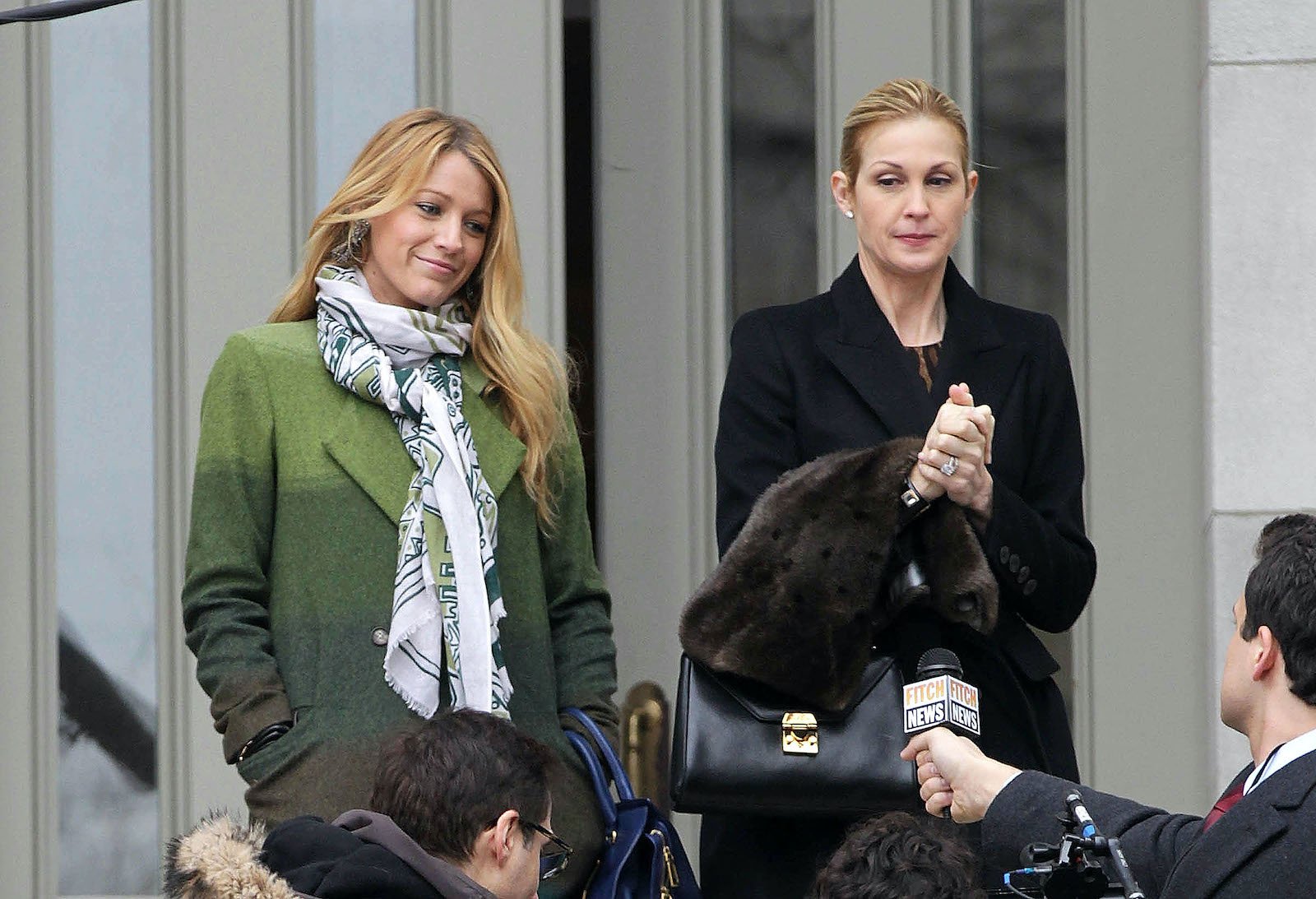 Blake Lively and Kelly Rutherford from 'Gossip Girl' on set and answering reporters' questions in front of a building 