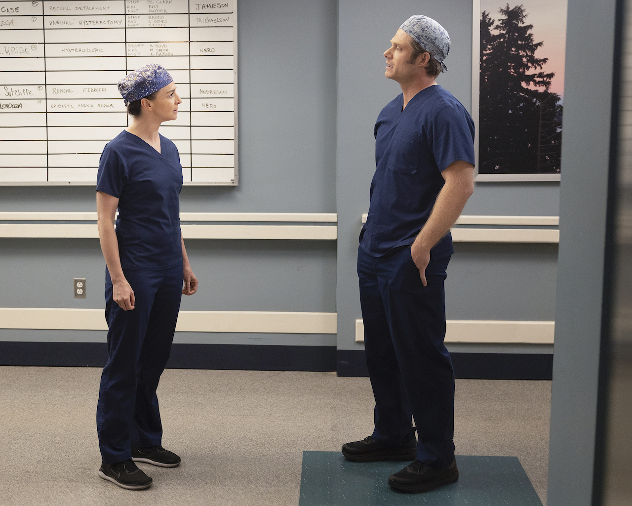 Caterina Scorsone as Amelia Shepherd and Chris Carmack as Atticus “Link” Lincoln talk in a hallway in the hospital in 'Grey's Anatomy'.