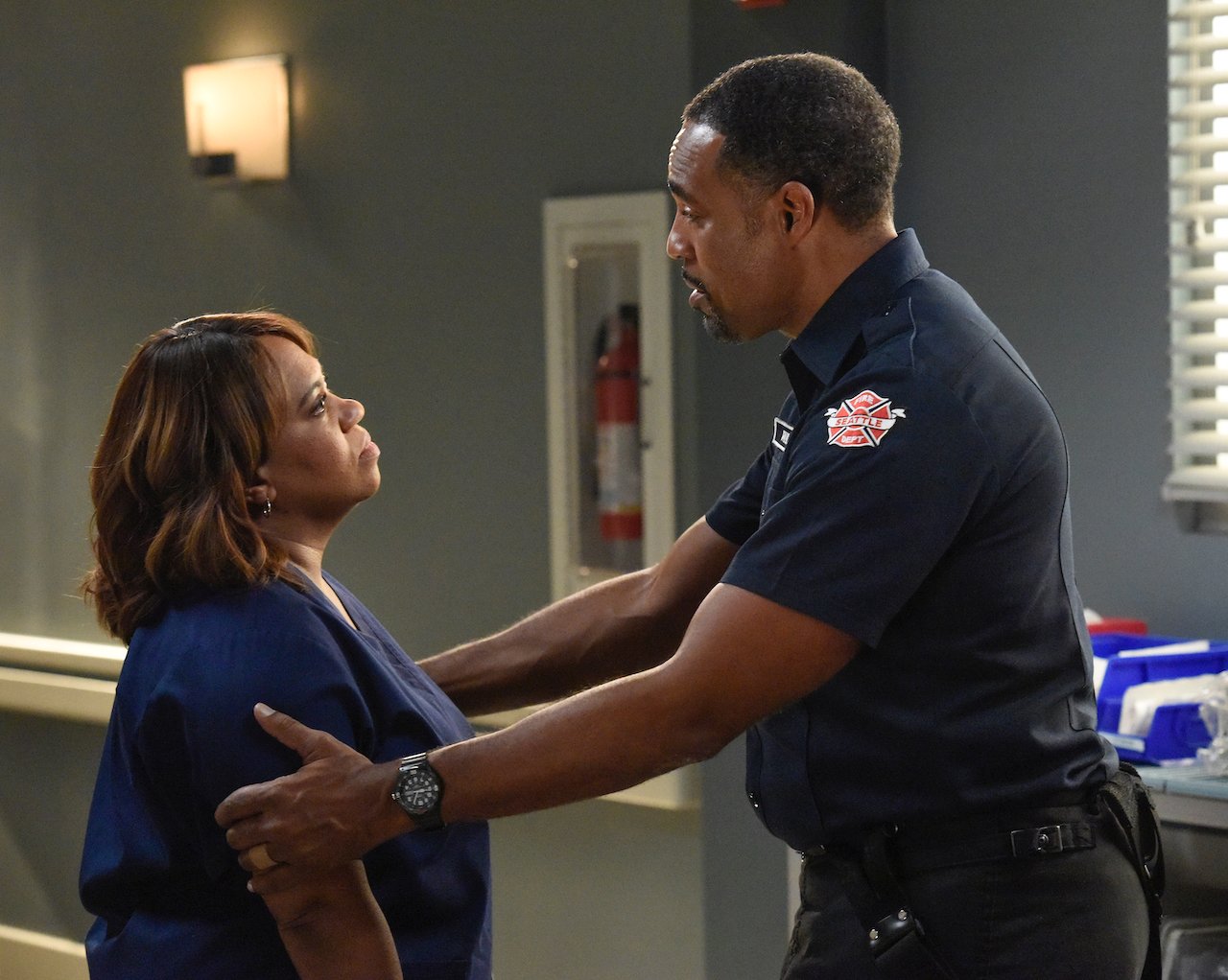 Chandra Wilson as Miranda and Jason George as Ben talk to each other in their uniforms in 'Grey's Anatomy'.