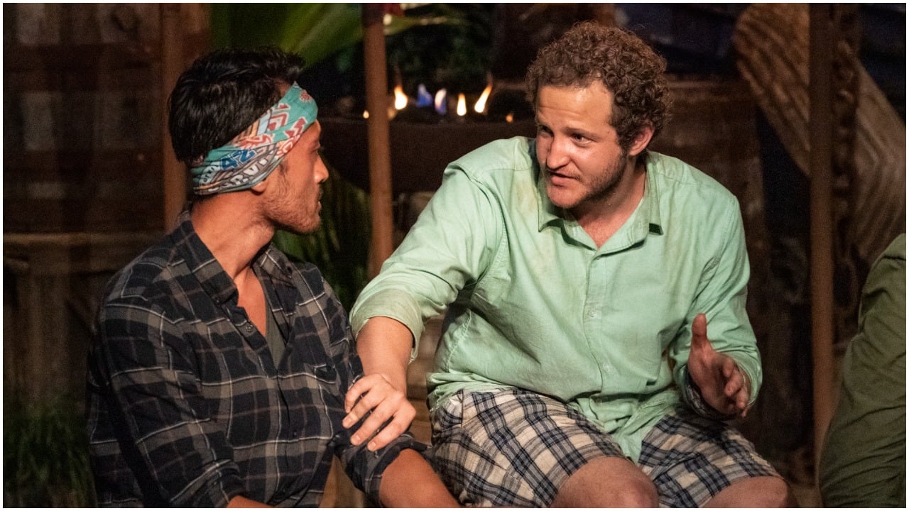 Daniel Strunk grabbing the arm of Hai Giang as they talk during Tribal Council