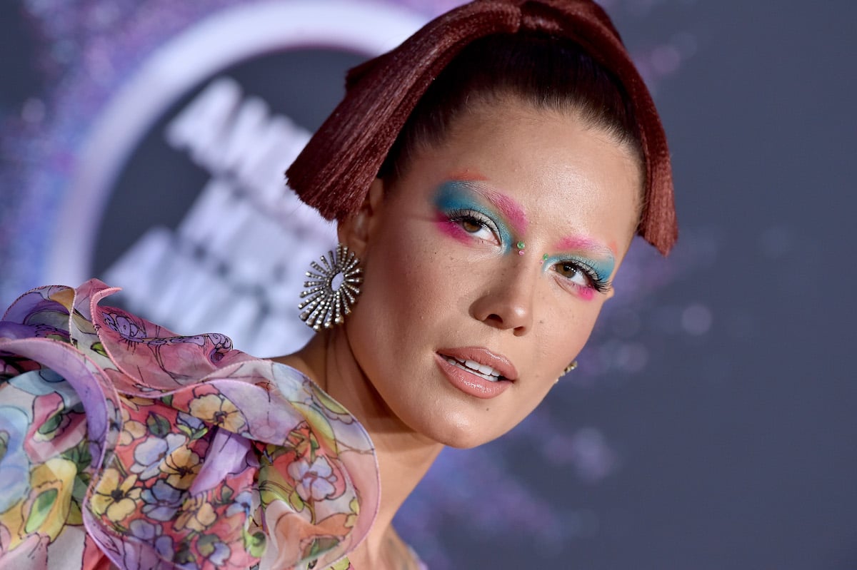 Halsey poses in pink and blue makeup at an event.