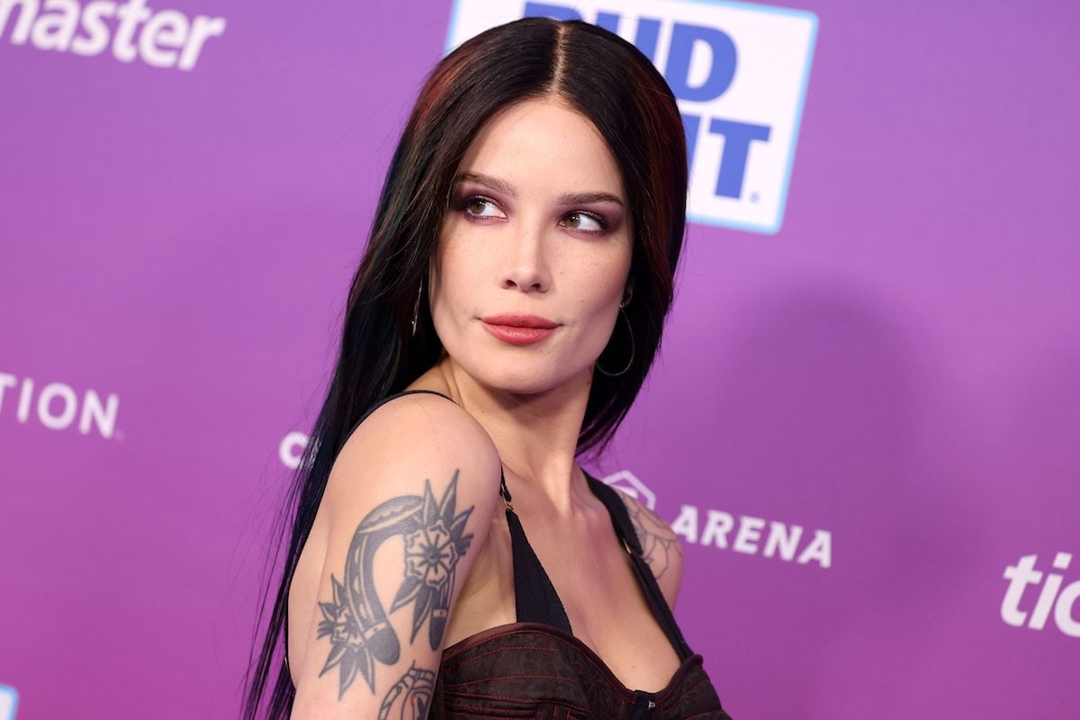 actor and singer Halsey looks over their tattooed shoulder