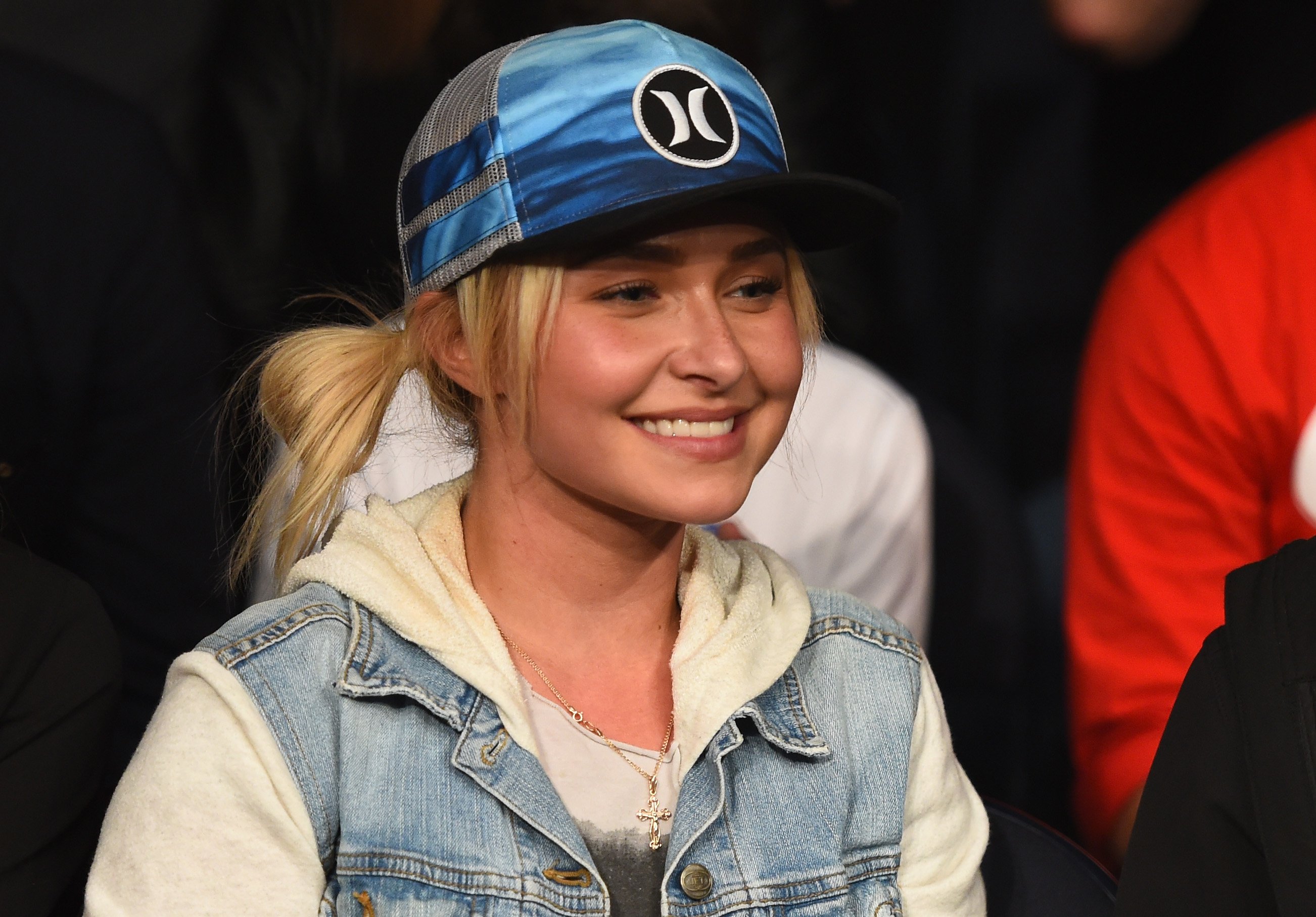 Actor Hayden Panettiere wears a ballcap and cream-colored hoodie in this photograph.