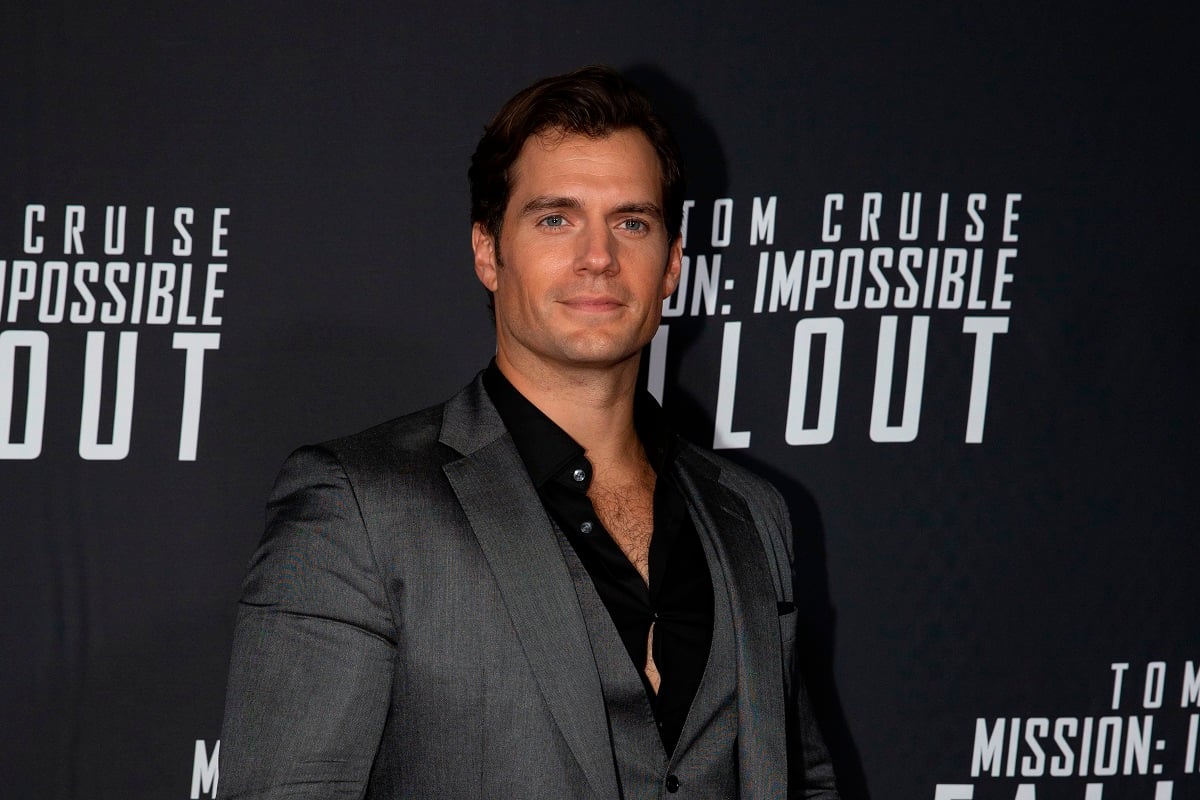 Henry Cavill posing while wearing a silver suit.