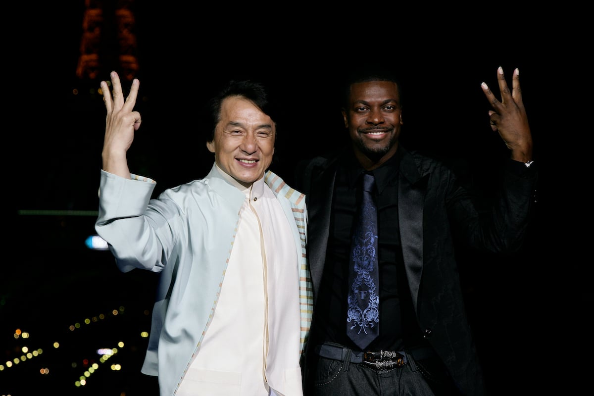 Jackie Chan and Chris Tucker pose and each hold up three fingers