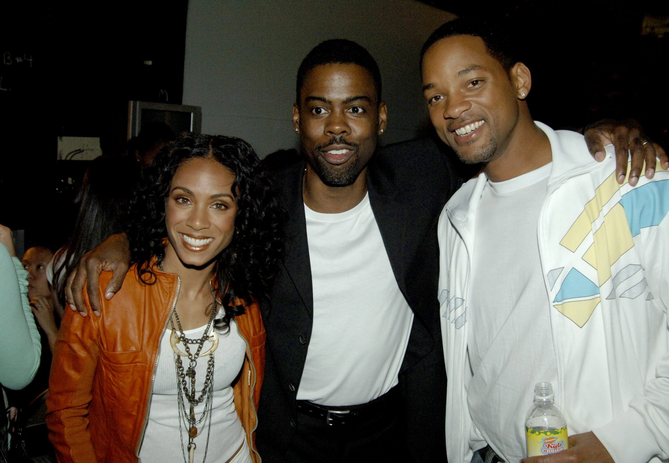 Jada Pinkett Smith, Chris Rock, and Will Smith pose together at an event.