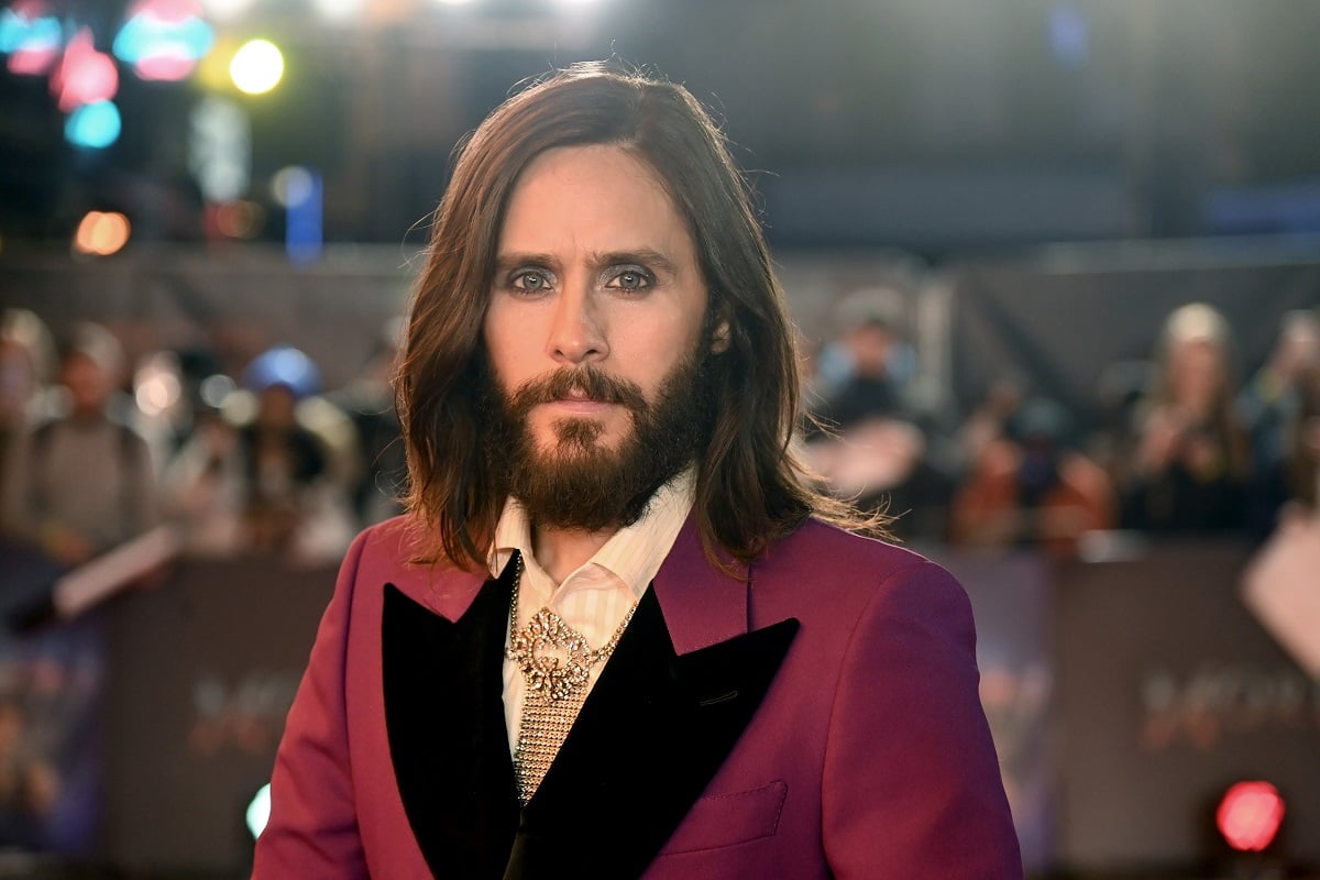 Jared Leto posing while wearing a purple suit.
