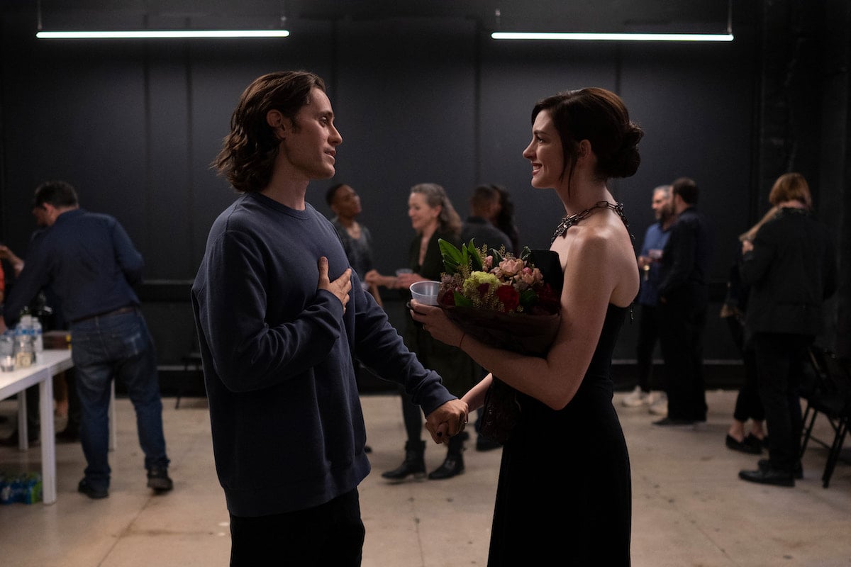Jared Leto stands in front of Anne Hathaway as she holds flowers in a scene from 'WeCrashed' Season 1 Episode 2: 'Masha Masha Masha'