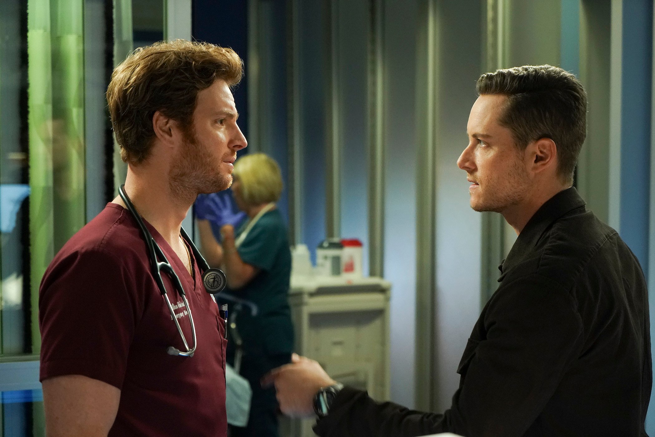Nick Gehlfuss as Will Halstead in 'Chicago Med' Season 7 and Jesse Lee Soffer as Jay Halstead in 'Chicago P.D.' Season 9 speaking to each other in a hospital