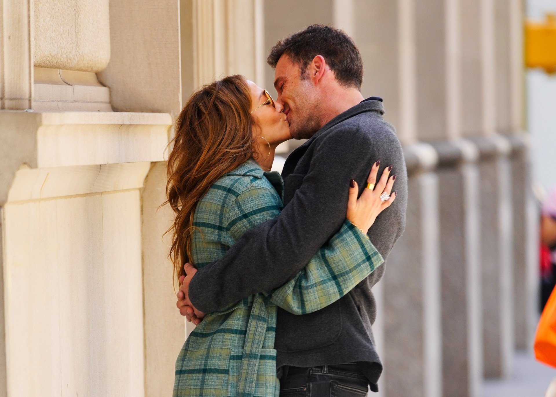 Jennifer Lopez and Ben Affleck embrace and kiss. 