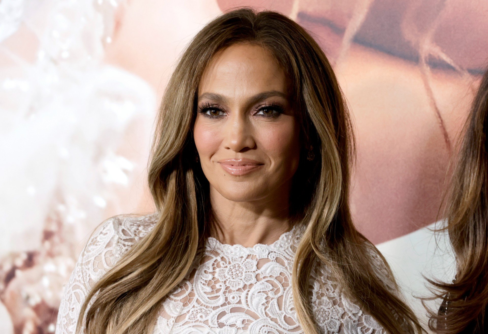 Jennifer Lopez wears a mini white wedding dress to the Marry Me movie premiere.