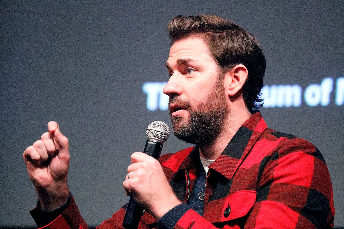 John Krasinski speaks while holding a microphone