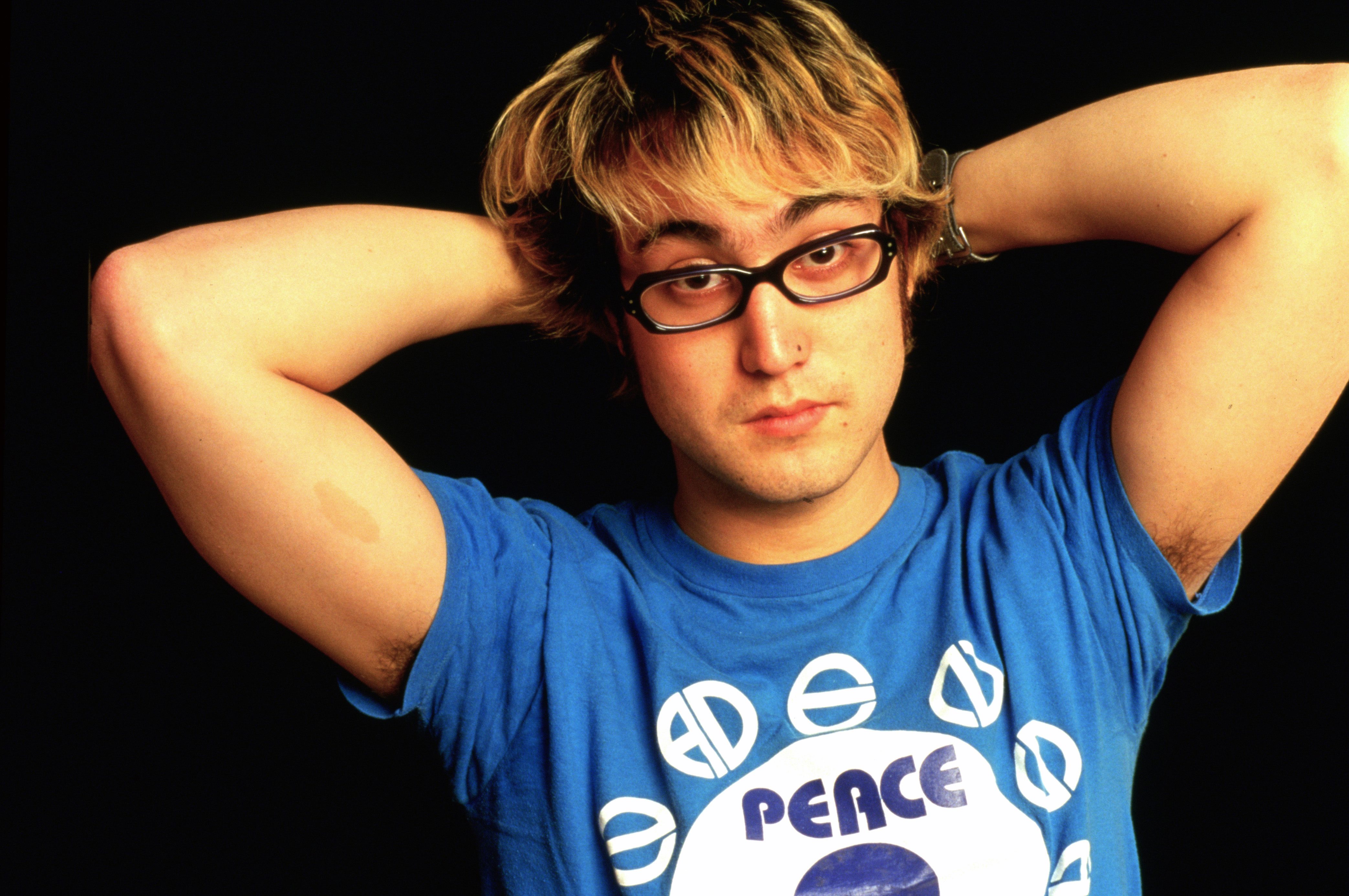 John Lennon's son, Sean Ono Lennon, wearing glasses and a blue shirt