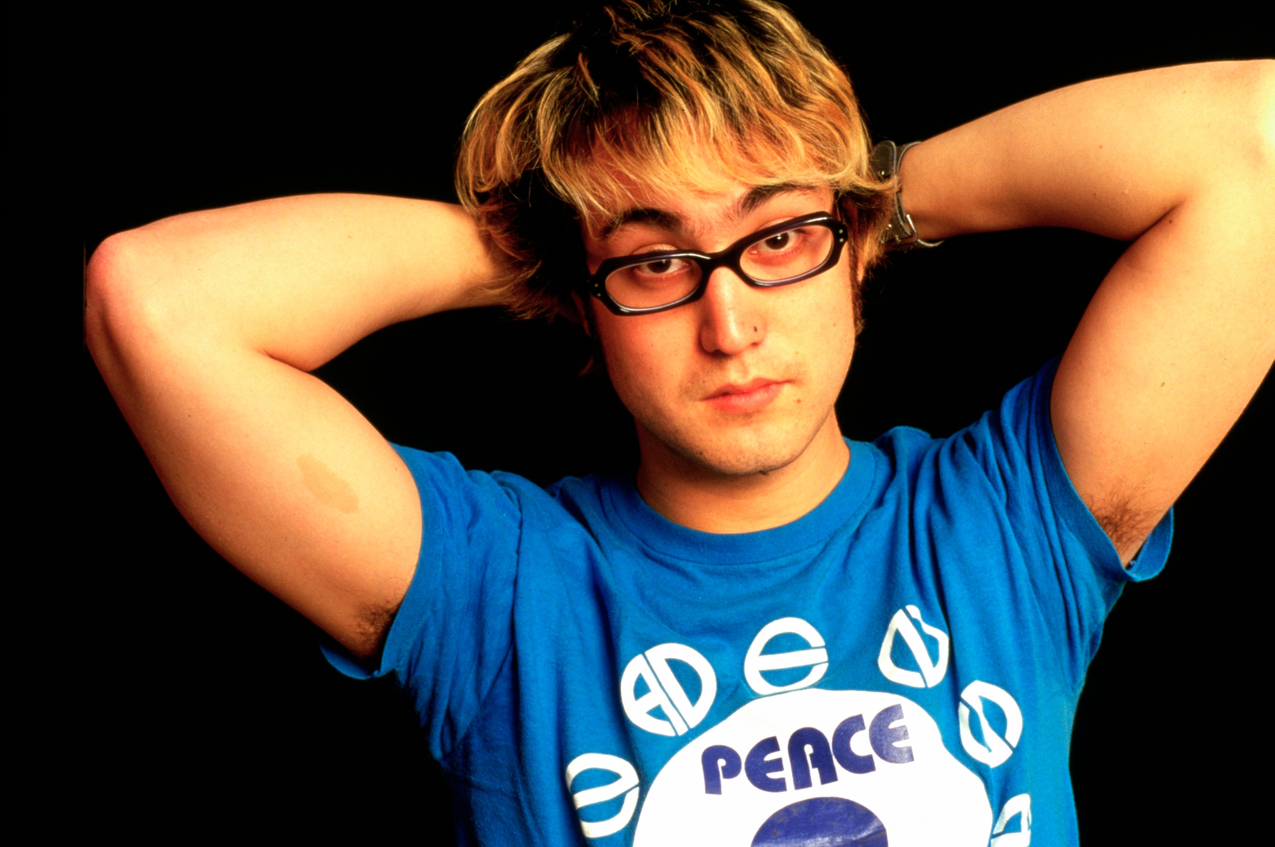 John Lennon's son, Sean Ono Lennon, wearing glasses and a blue shirt