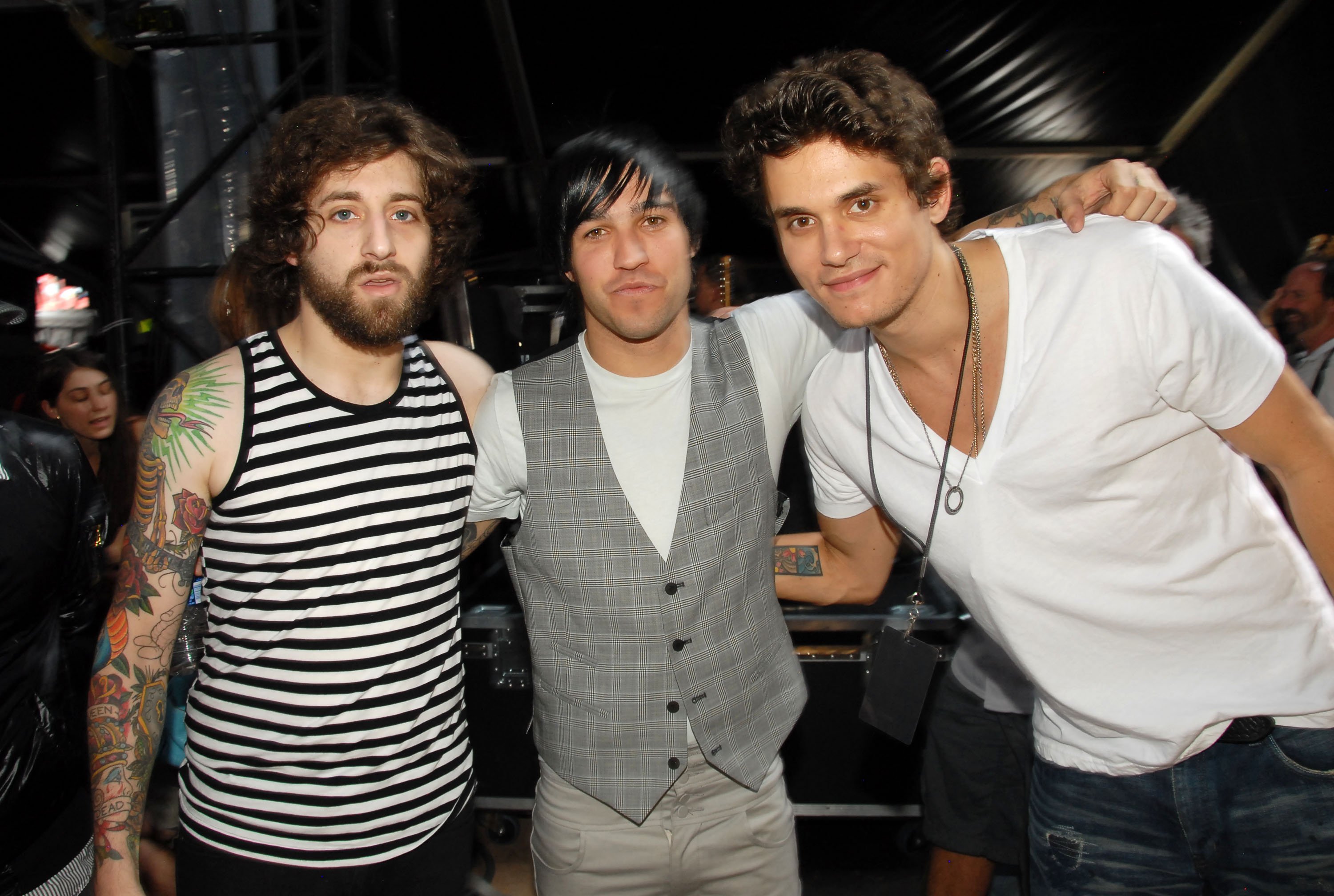 Joe Trohman and Pete Wentz of Fall Out Boy and John Mayer putting their arms around each other