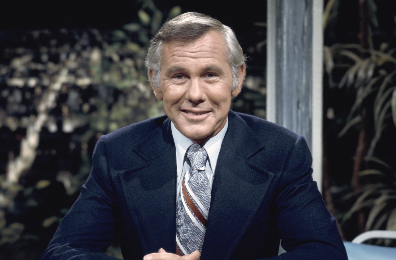 Johnny Carson in a Navy blue jacket, seated at 'The Tonight Show' desk