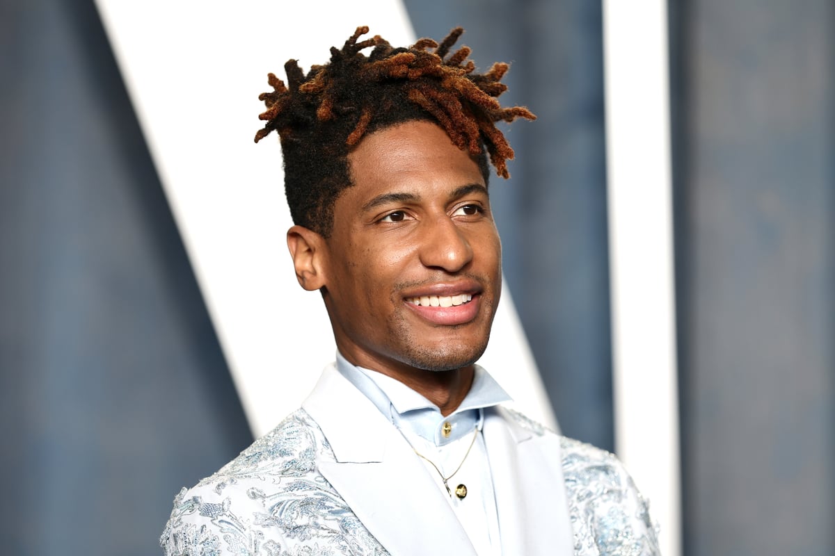Jon Batiste wearing a light blue suit and posing for a photo at the Vanity Fair Oscar party in Beverly Hills, CA.