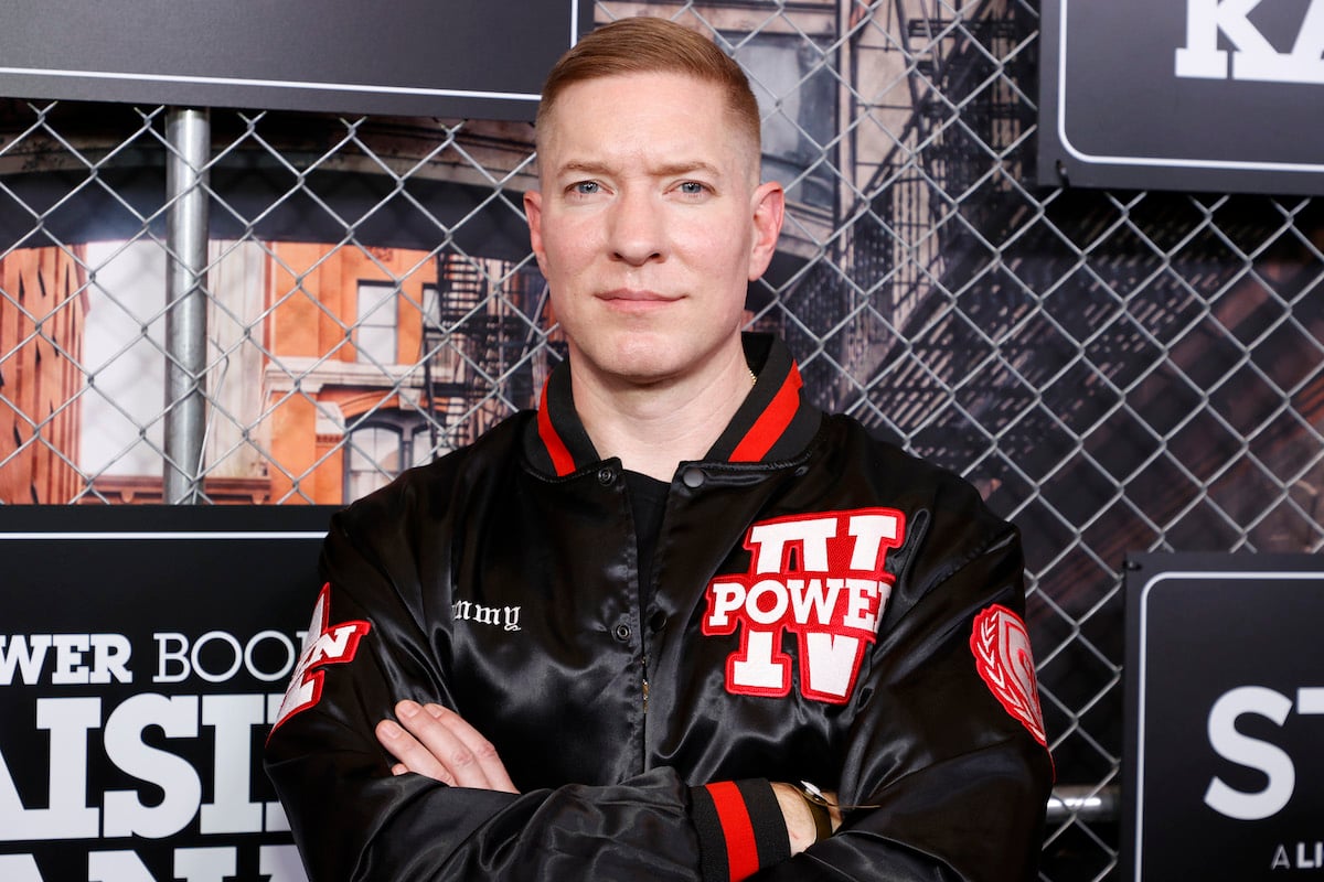 Joseph Sikora wears a red and black jacket and poses for cameras at a TV event
