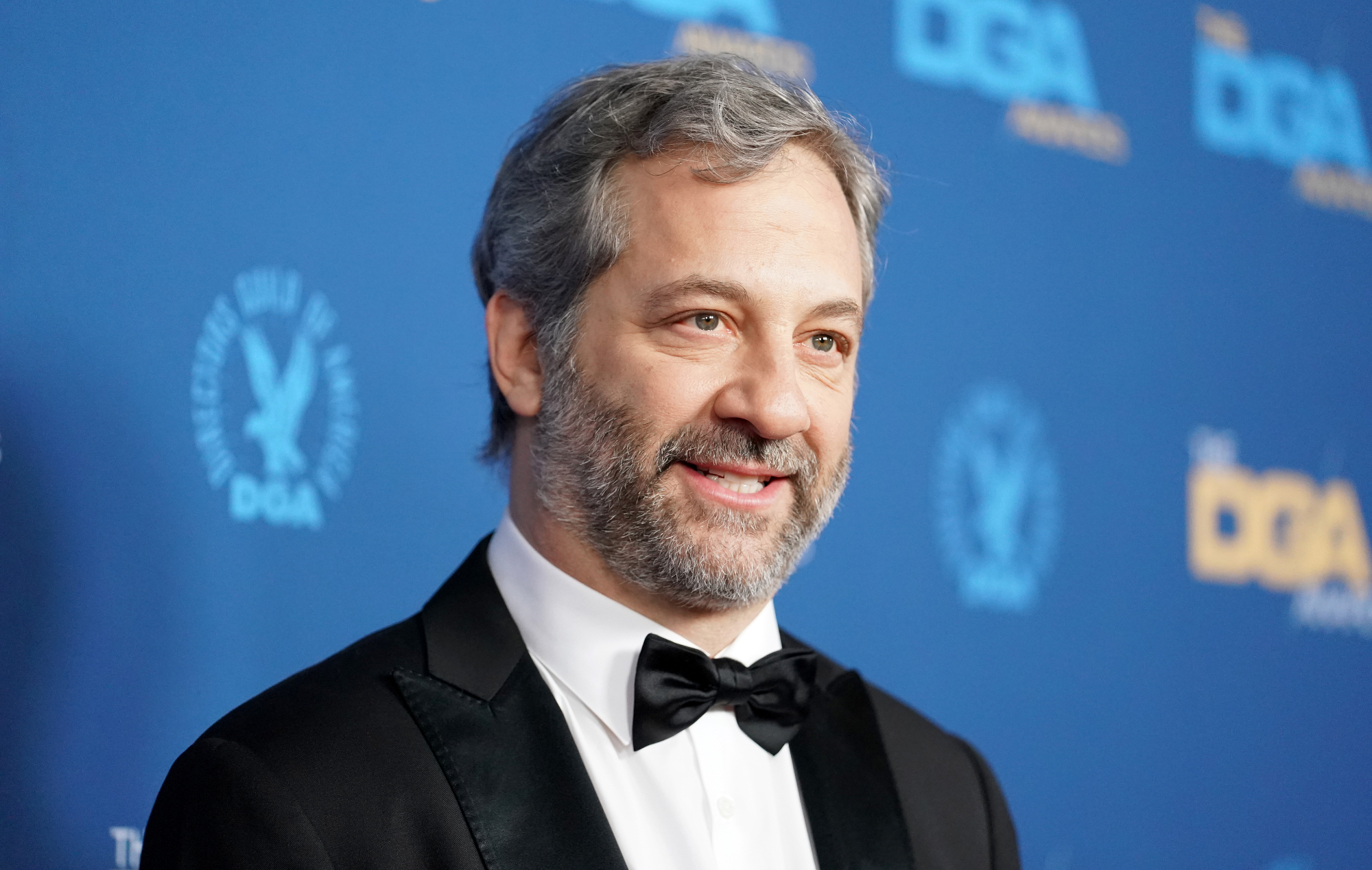 Judd Apatow before Oscars 2022 season in tux in front of blue step and repeat