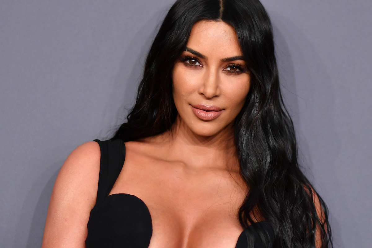Kim Kardashian poses in a black dress at an event.