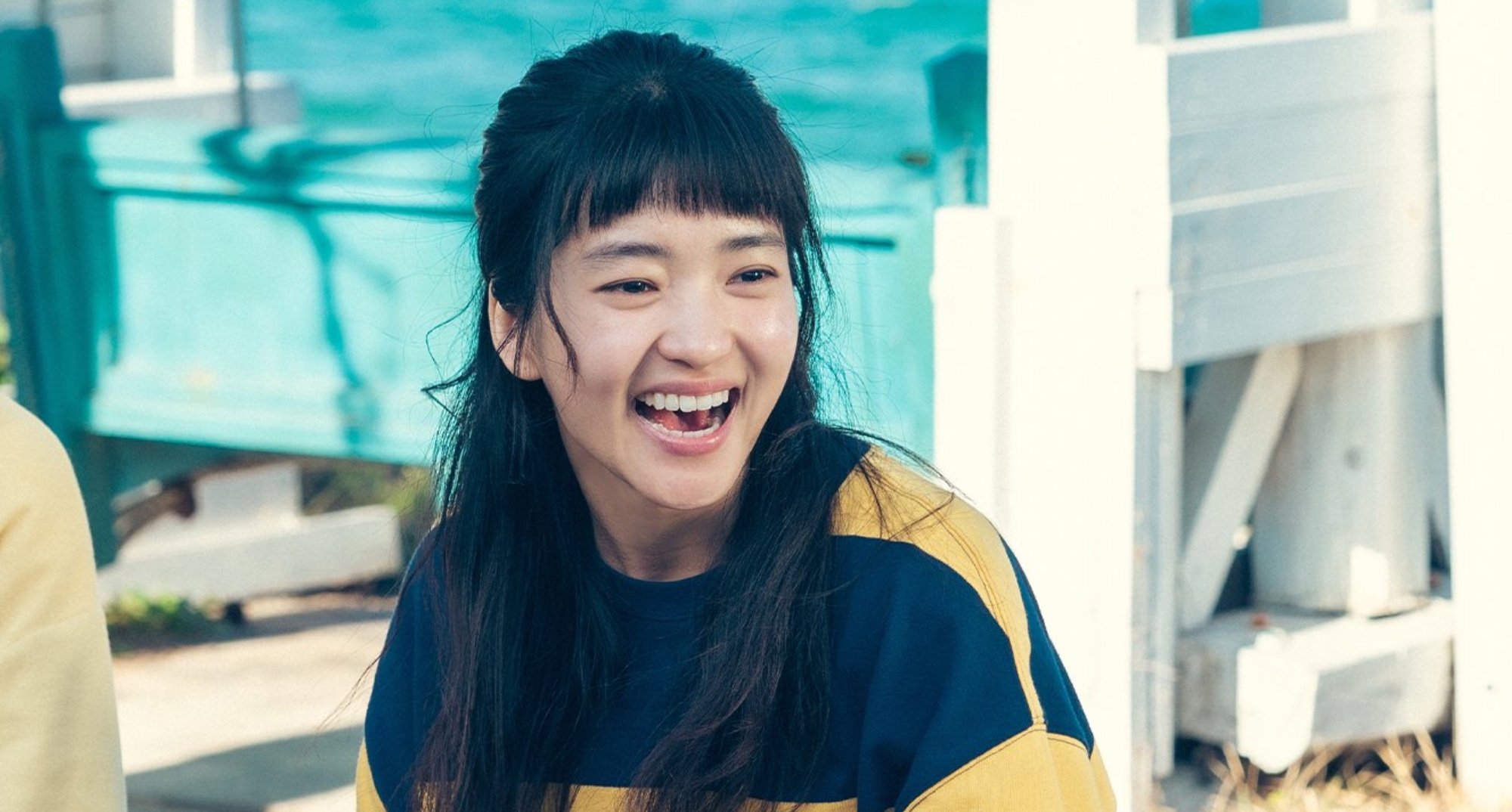 Kim Tae-ri as Hee-do in 'Twenty-Five Twenty-One' laughing wearing stripped shirt.