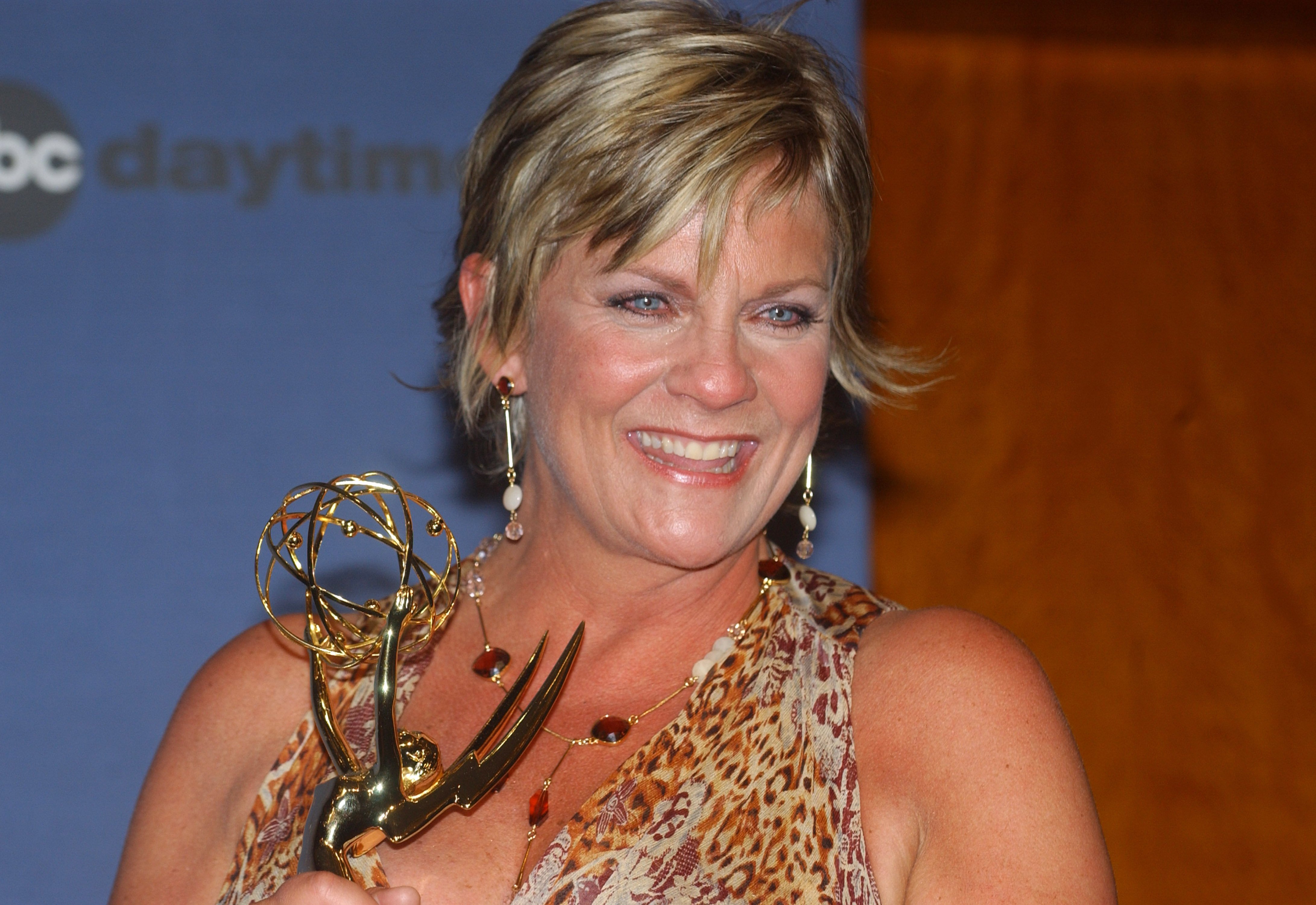 'Guiding Light' actor Kim Zimmer wearing a leopard print dress and holding a Daytime Emmy.