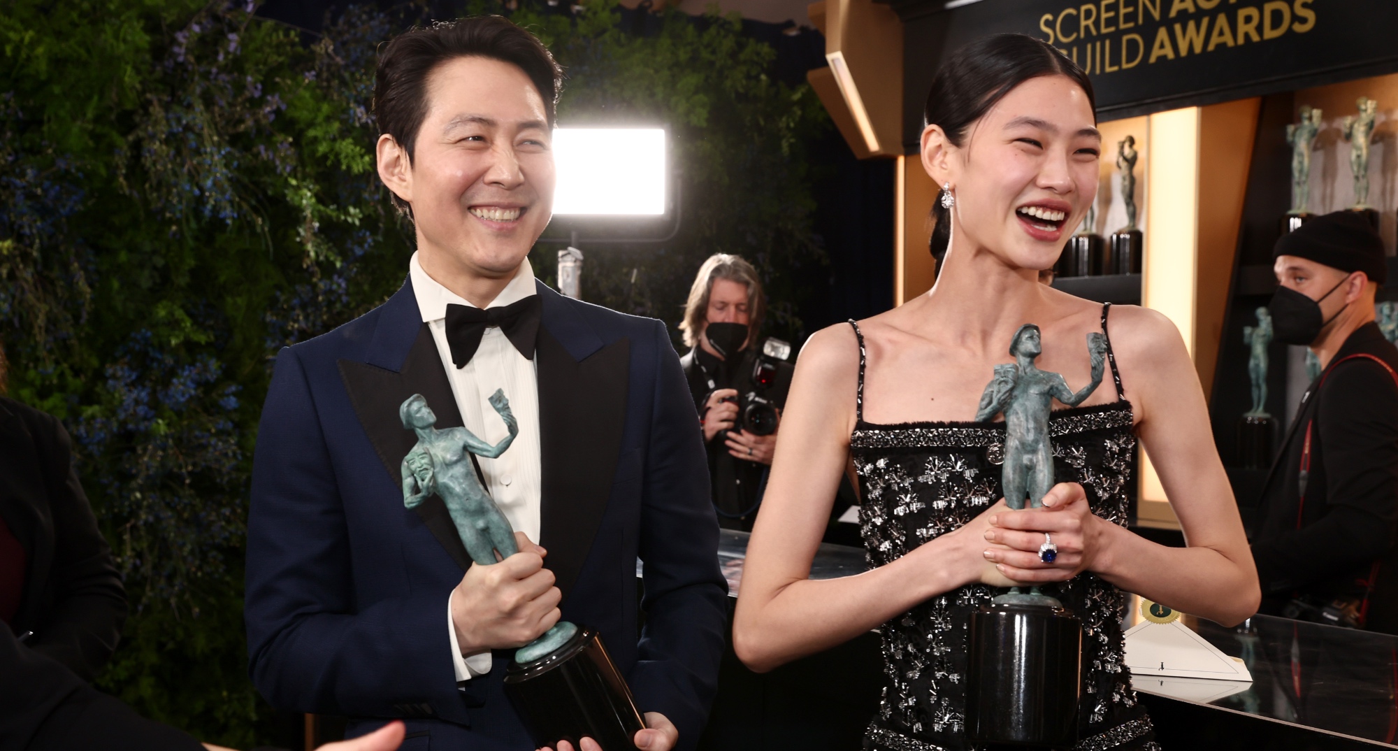 Lee Jung-jae and HoYeon Jung at 2022 SAG Awards backstage holding awards.