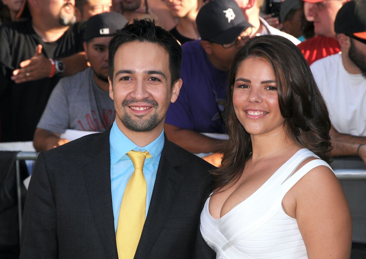 Lin-Manuel Miranda wears a suit and Vanessa Nadal wears a dress on the red carpet
