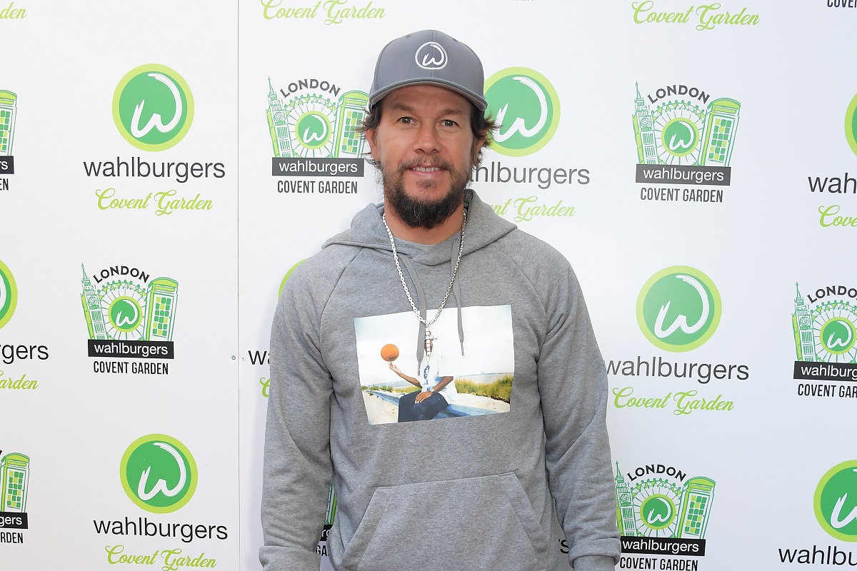 Mark Wahlberg smiling while wearing a grey sweater.