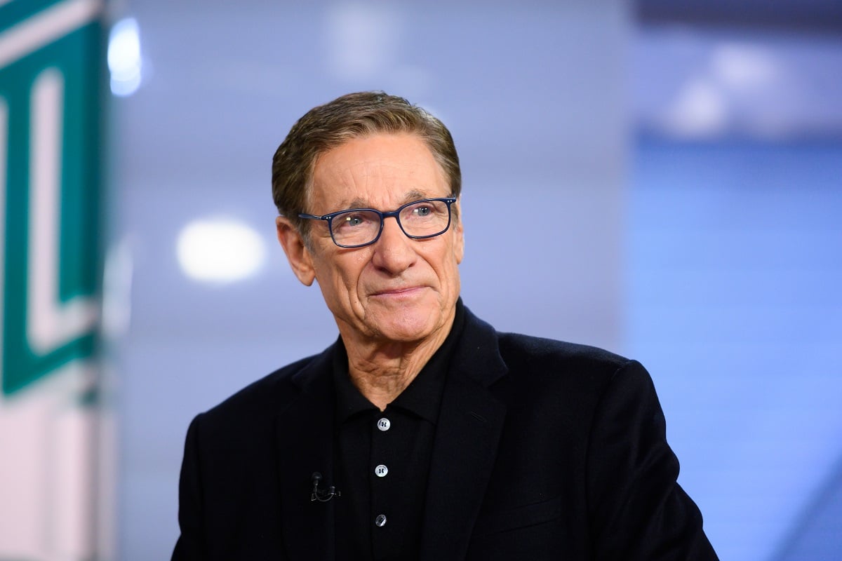 'Maury' host Maury Povich wearing a black suit and eyeglasses during a TV show appearance.