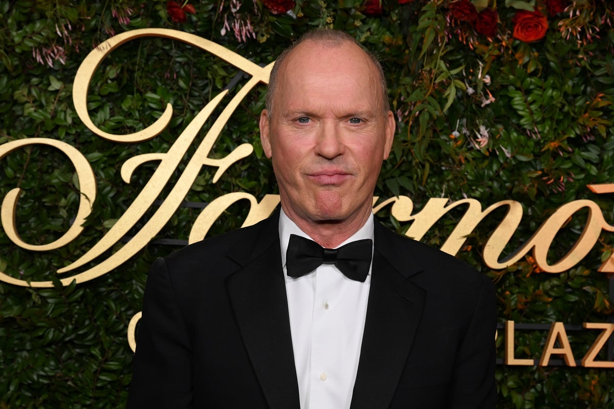 Michael Keaton posing while wearing a suit.