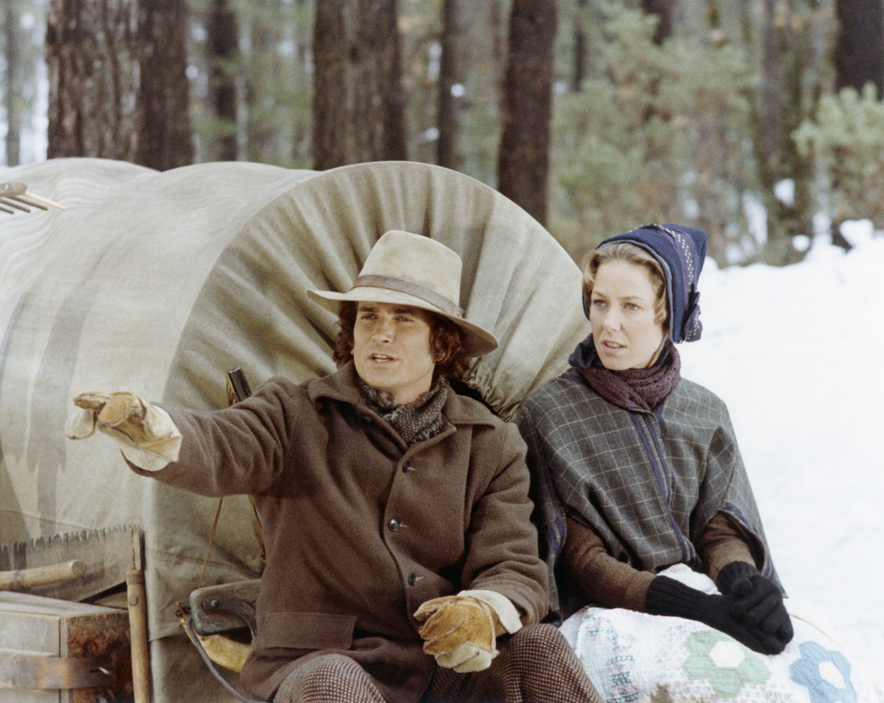 Michael Landon as Charles Ingalls and Karen Grassle as Caroline Ingalls sit in a wagon on Little House in the Prairie.