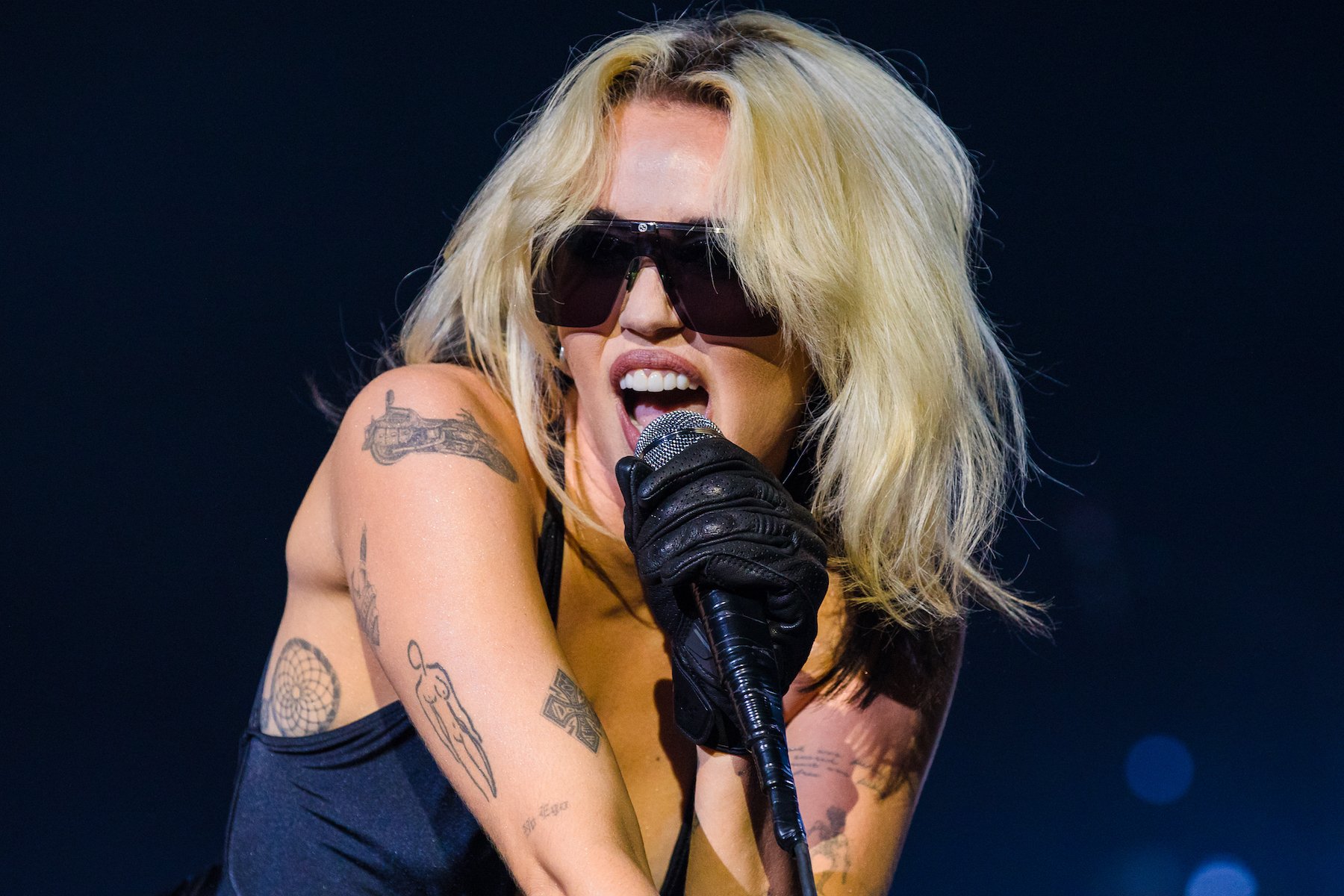 Miley Cyrus wearing sunglasses performing