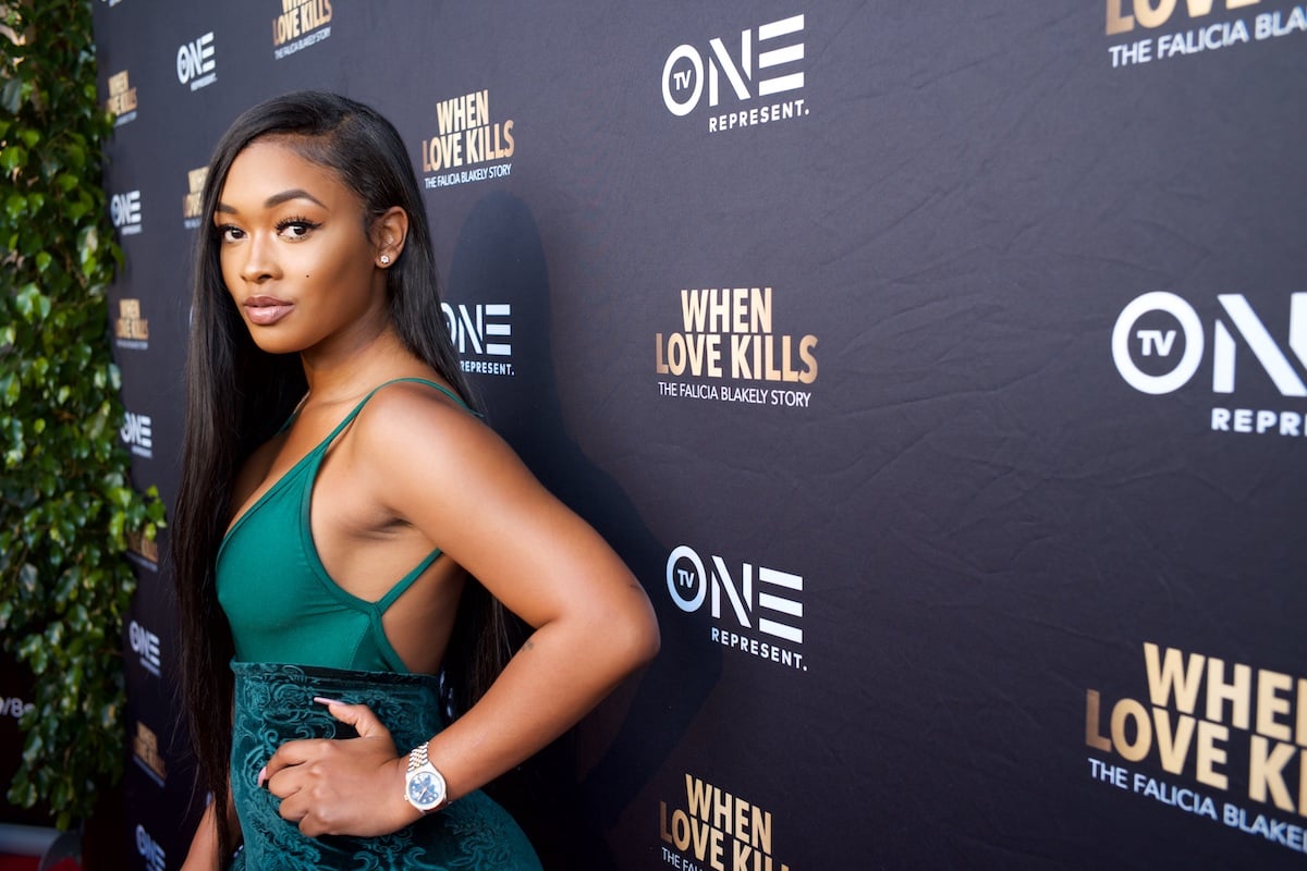 Miracle Watts attends the Premiere Of TV One's "When Love Kills" wearing a green dress