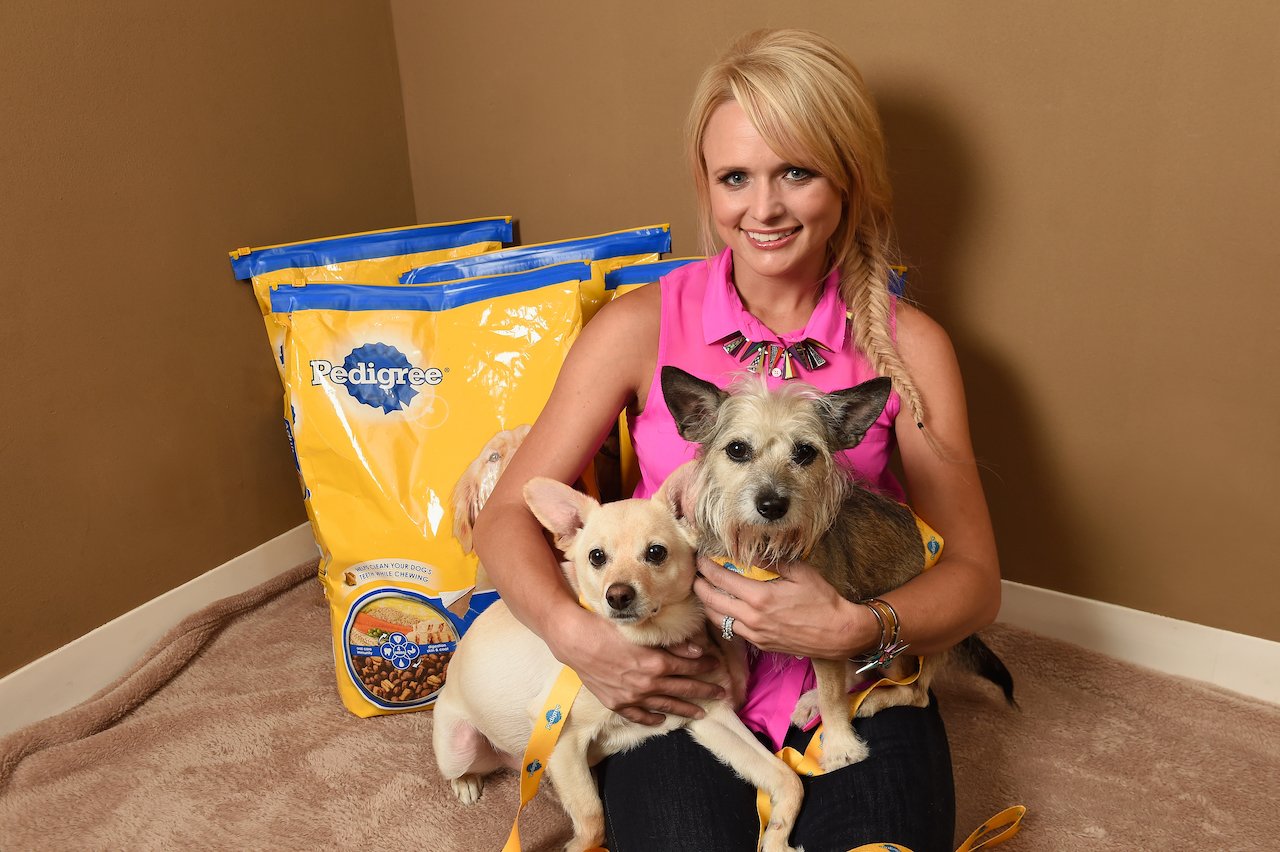 Miranda Lambert smiles while holding two small dogs