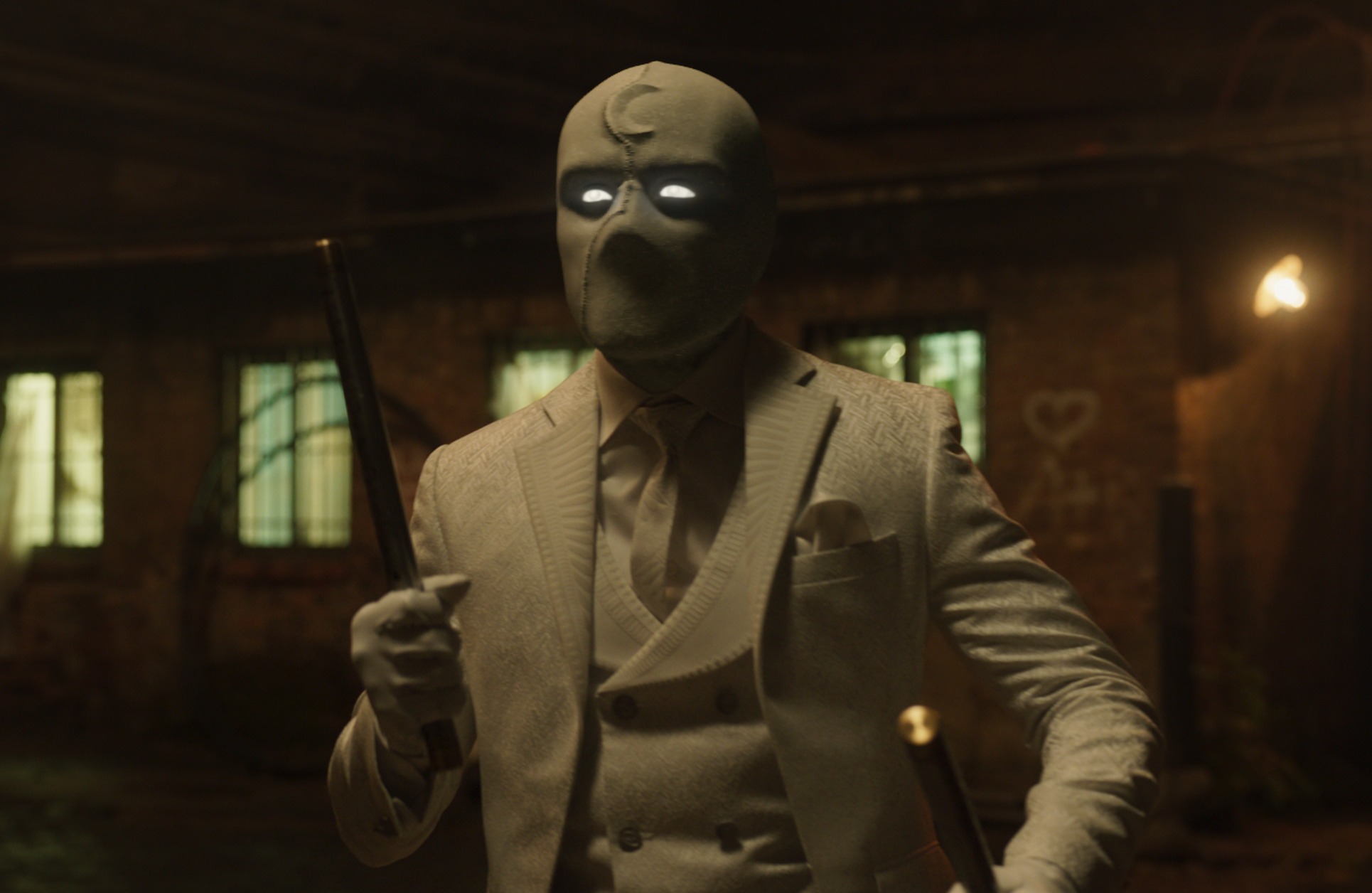 Oscar Isaac in an episode of Marvel's 'Moon Knight.' He's wearing the character's costume, which includes a mask with a sickle moon on it, suit, and cane.