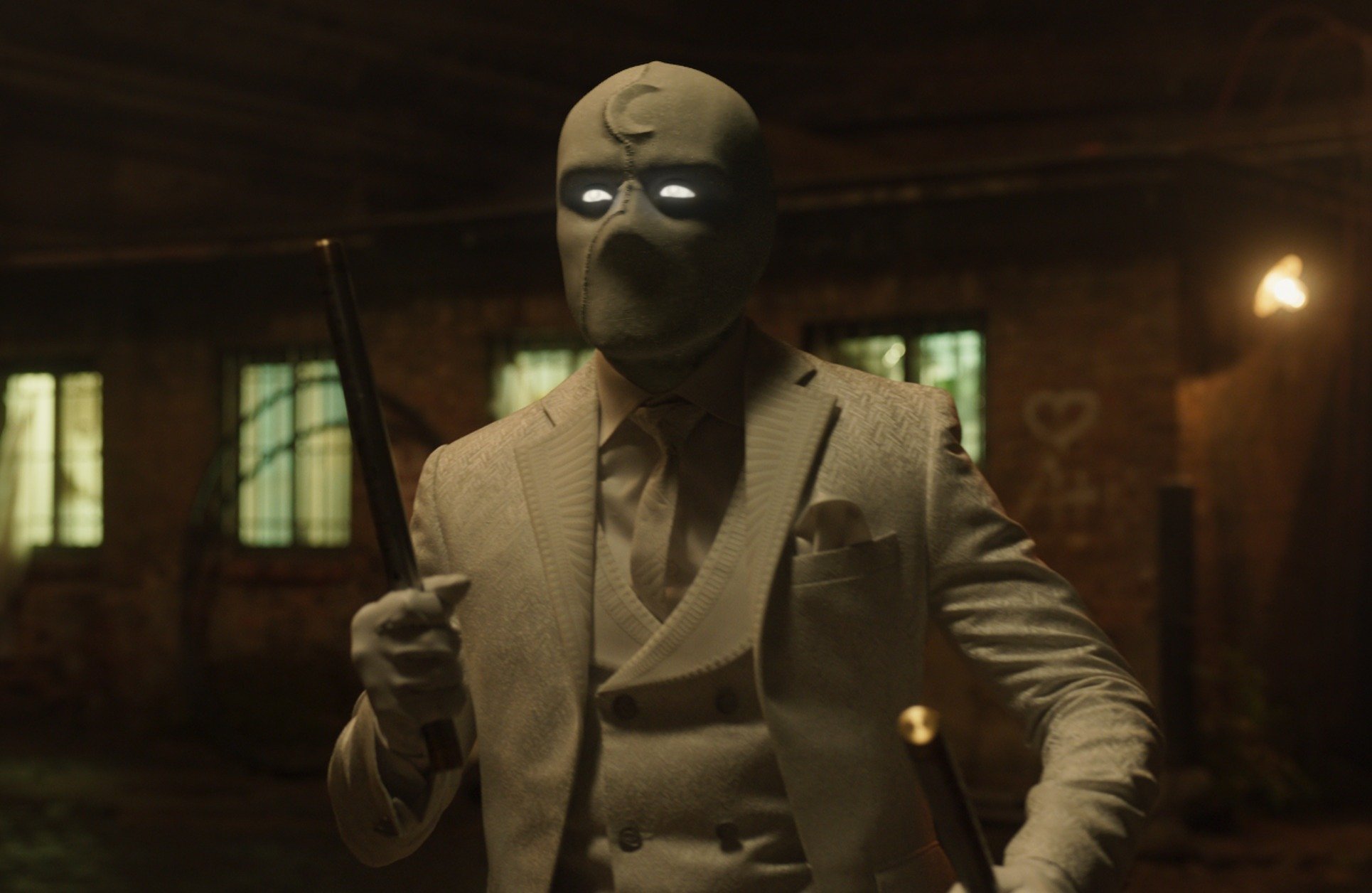 Oscar Isaac in an episode of Marvel's 'Moon Knight.' He's wearing the character's costume, which includes a mask with a sickle moon on it, suit, and cane.