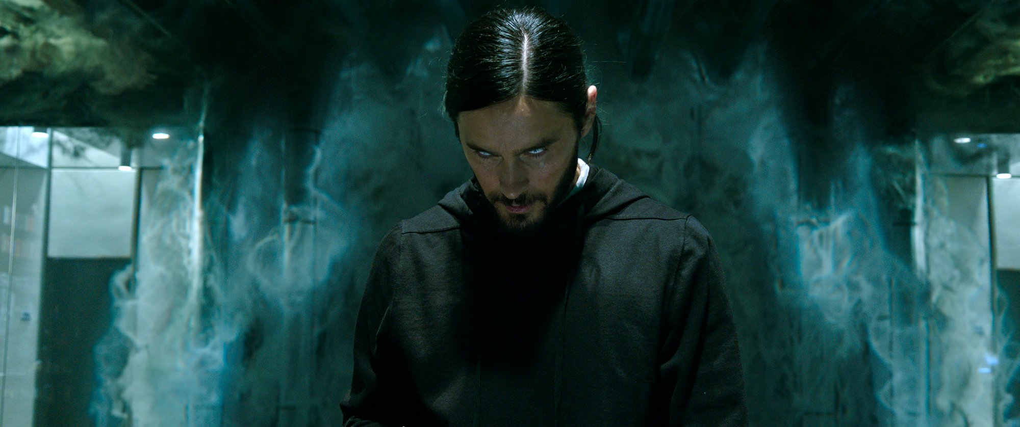 'Morbius' Jared Leto as Dr. Michael Morbius with white eyes looking from under his brow wearing a black hoodie