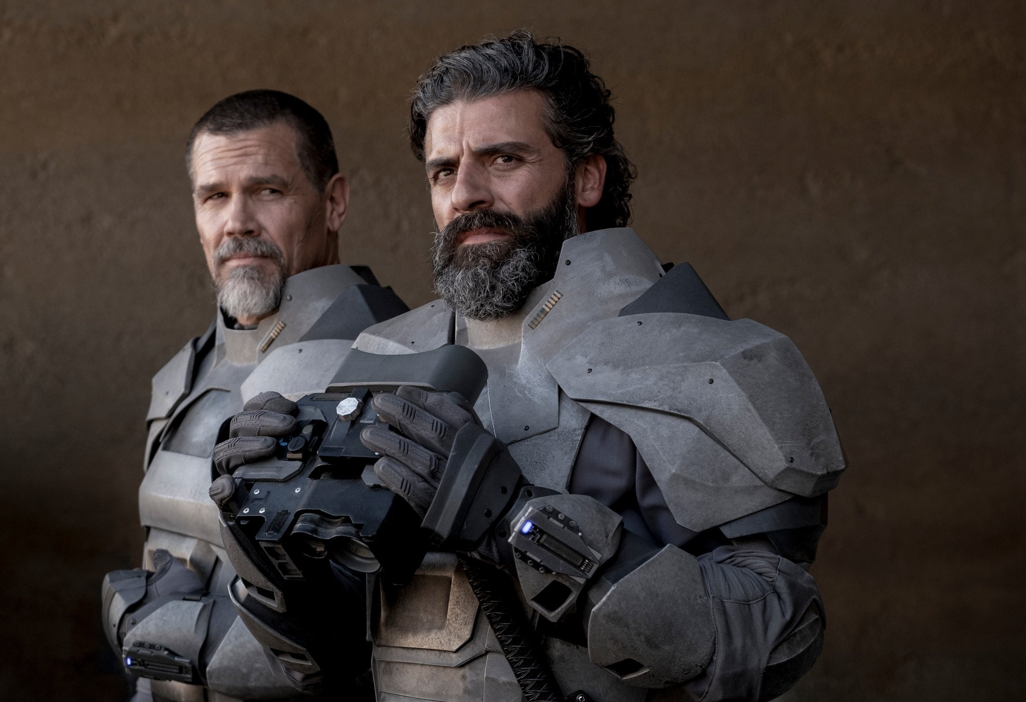 Josh Brolin and Oscar Isaac in 'Dune.' Oscar Isaac's character is holding a helmet, and Brolin's is standing behind him.
