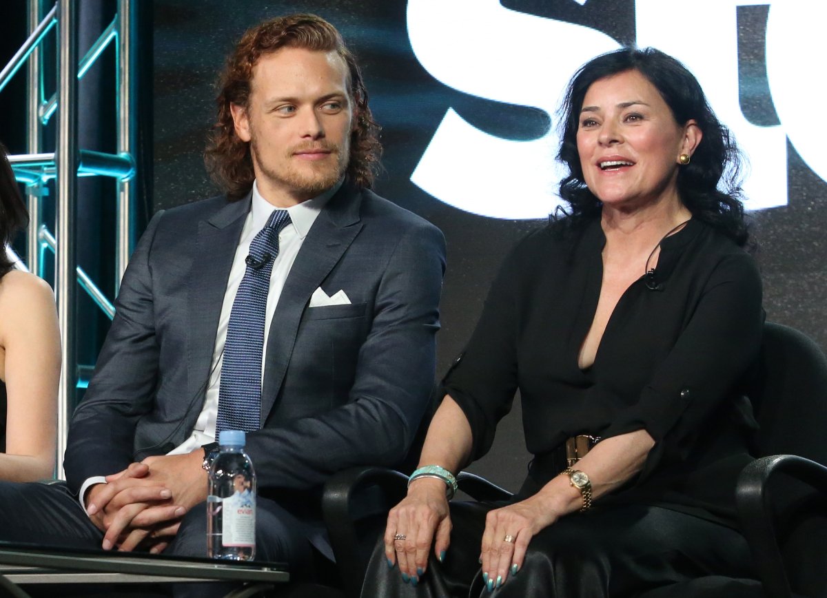 Outlander author Diana Gabaldon wearing all black and actor Sam Heughan in a suit with his long red hair speak onstage during as part of the Starz portion of This is Cable 2016 Television Critics Association Winter Tour at Langham Hotel on January 8, 2016